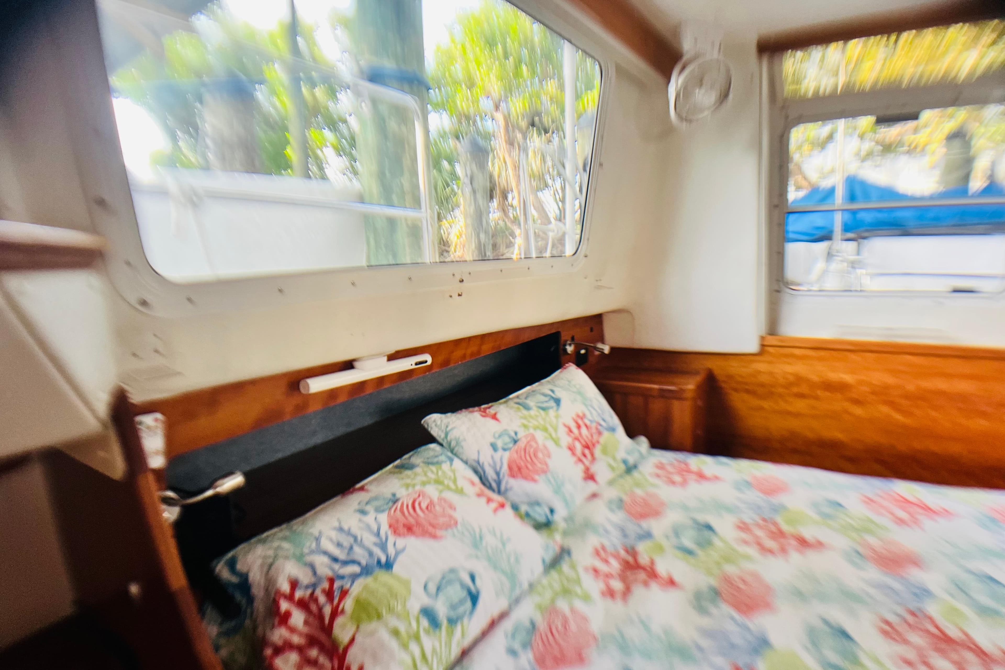 Cozy cabin interior of 2007 PDQ MV41 with floral bedding and large windows.