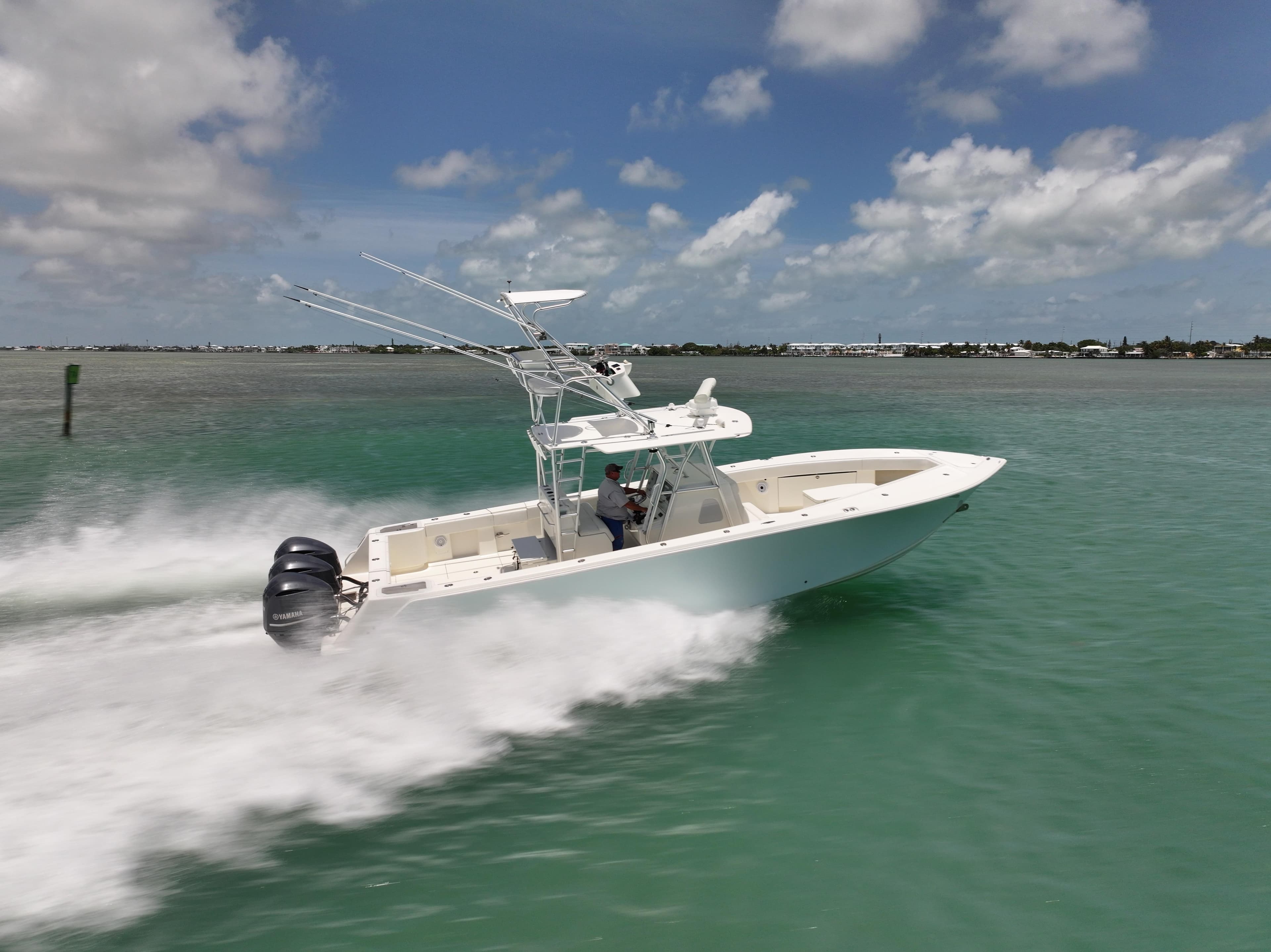 2015 SeaVee 370z boat speeding on turquoise water under a clear sky.