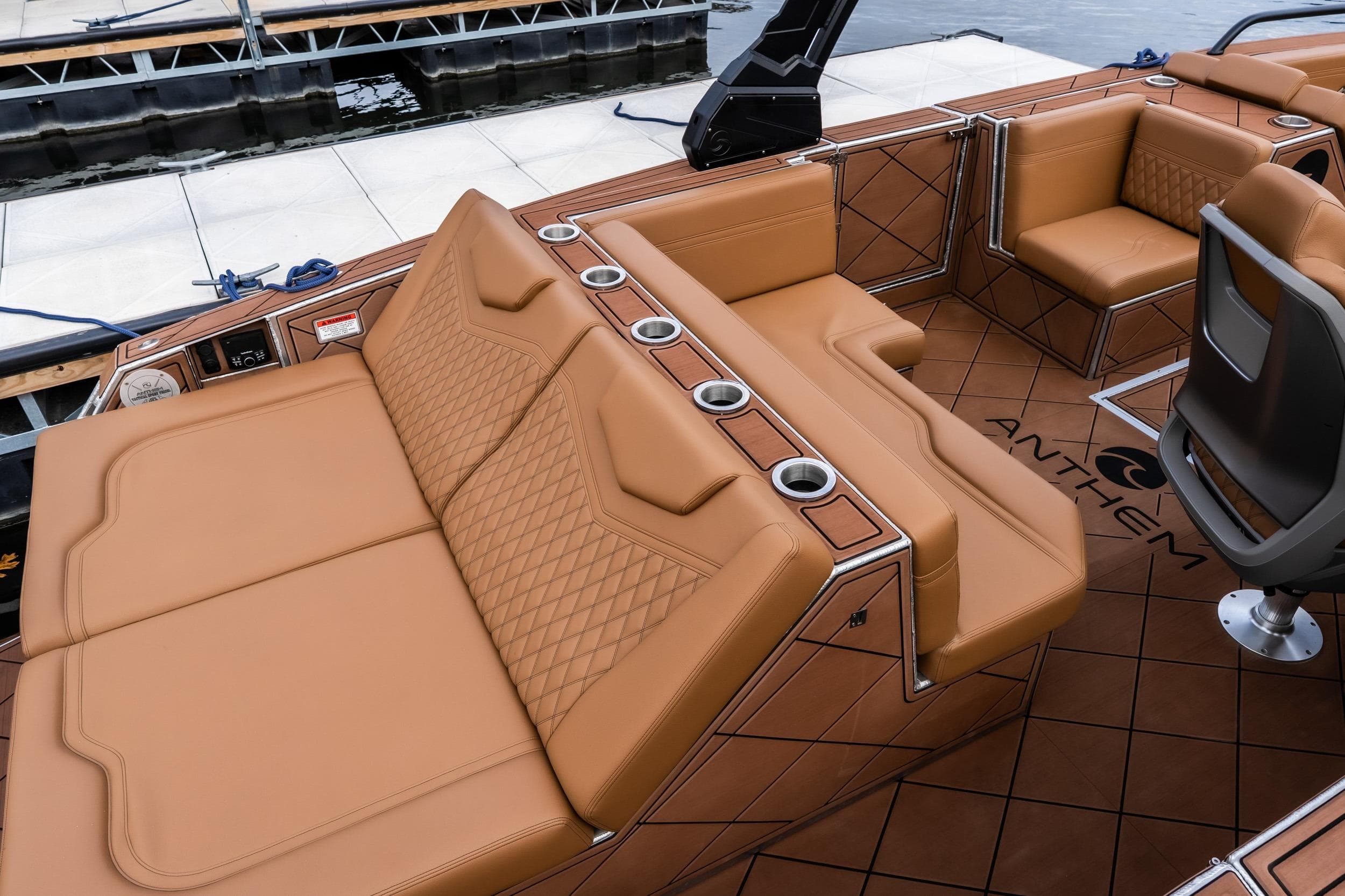 Luxurious interior of 2026 Anthem Assault ST23 boat with tan leather seating and cup holders.