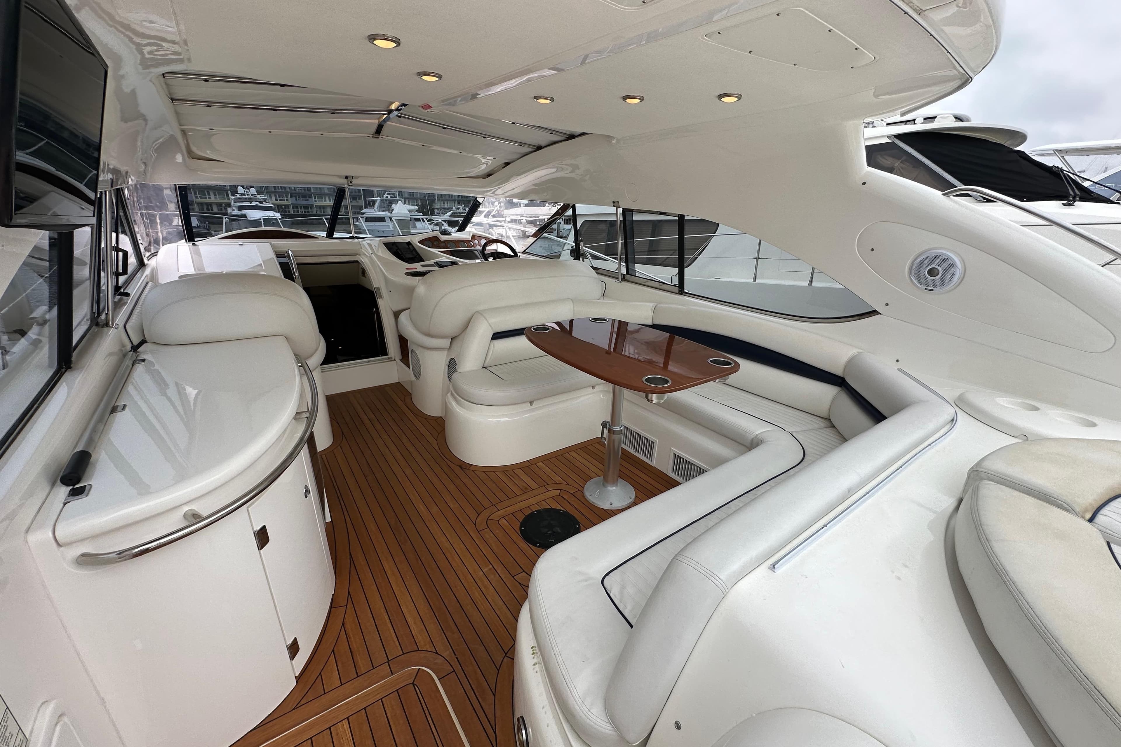Luxurious interior of 2000 Sunseeker Predator 60 yacht with elegant seating and wooden flooring.