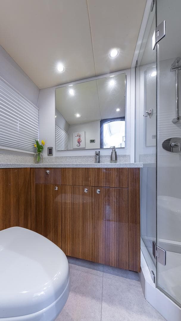 Luxurious bathroom in 2010 Custom 650 Catamaran with modern fixtures and wood cabinetry.