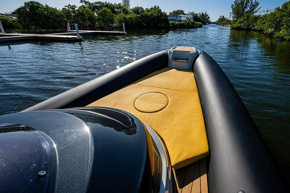 2025 SACS Strider 11 luxury boat with yellow seating, cruising on a serene waterway.