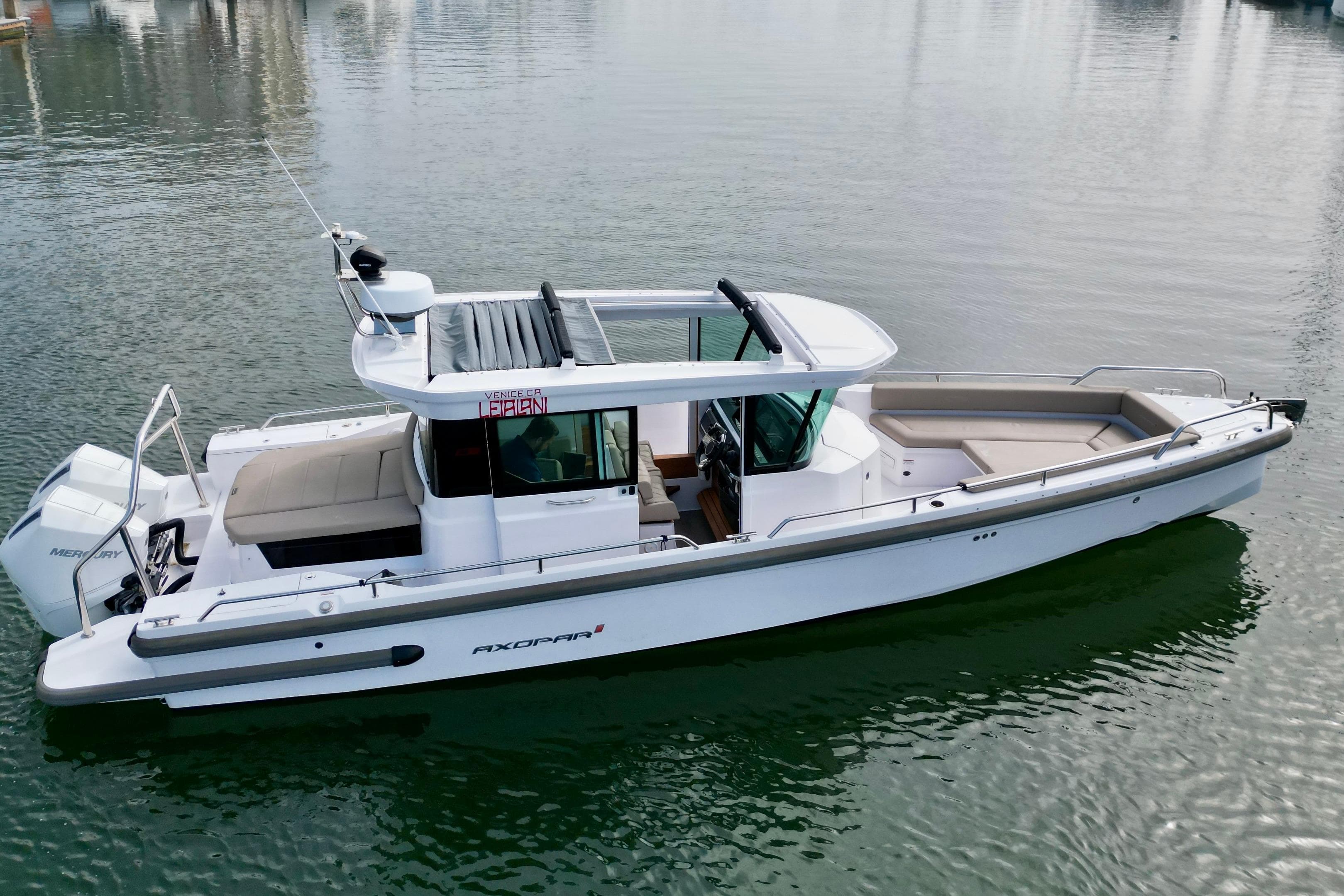 2023 Axopar 28 Cabin boat on calm water, showcasing sleek design and modern features.