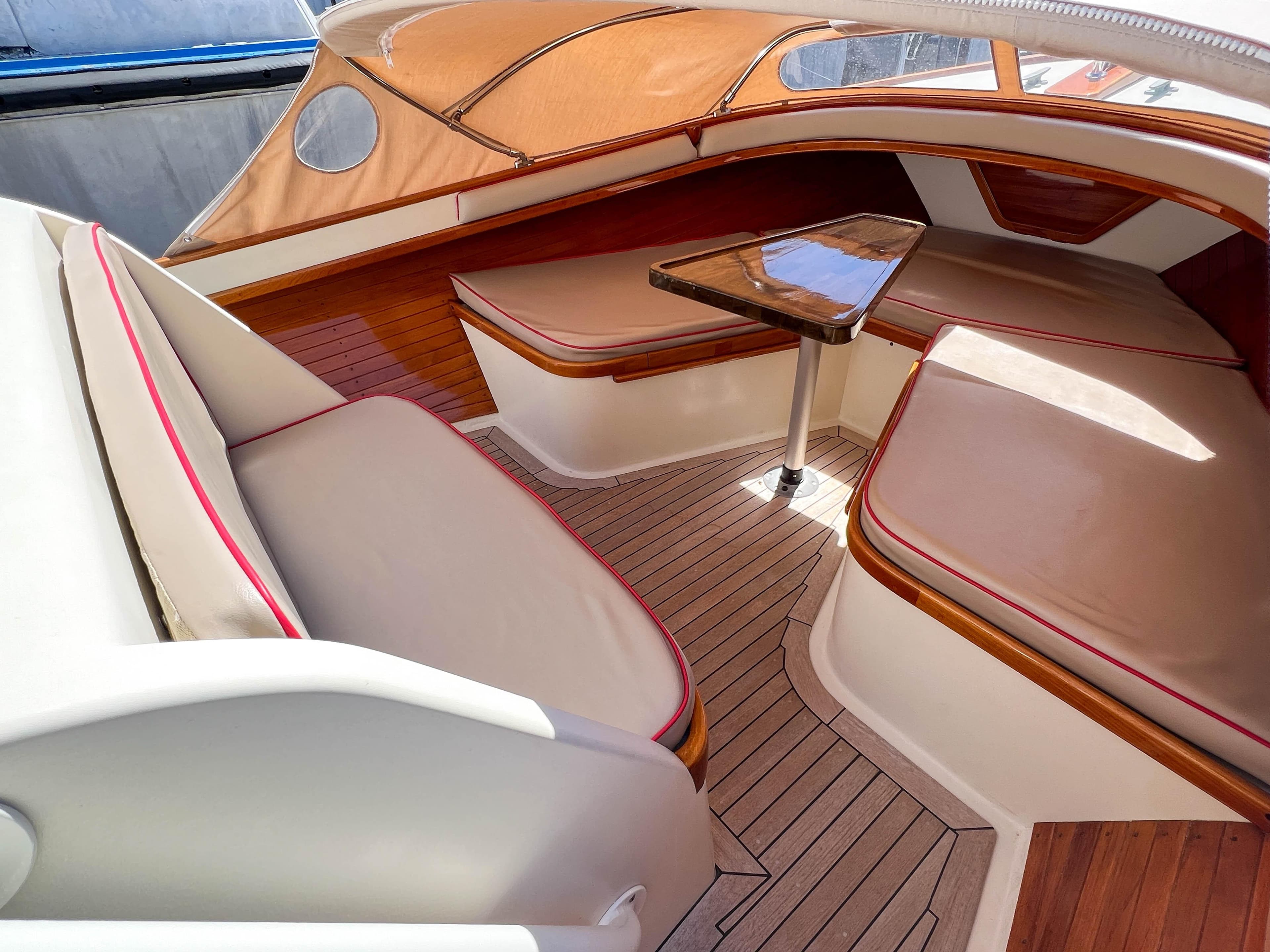 Luxurious interior of 2003 Padebco V27 Center Console with cushioned seating and wooden accents.