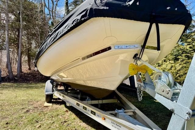 2024 Zodiac Medline 7.5 GT boat on trailer, covered, parked on grass.