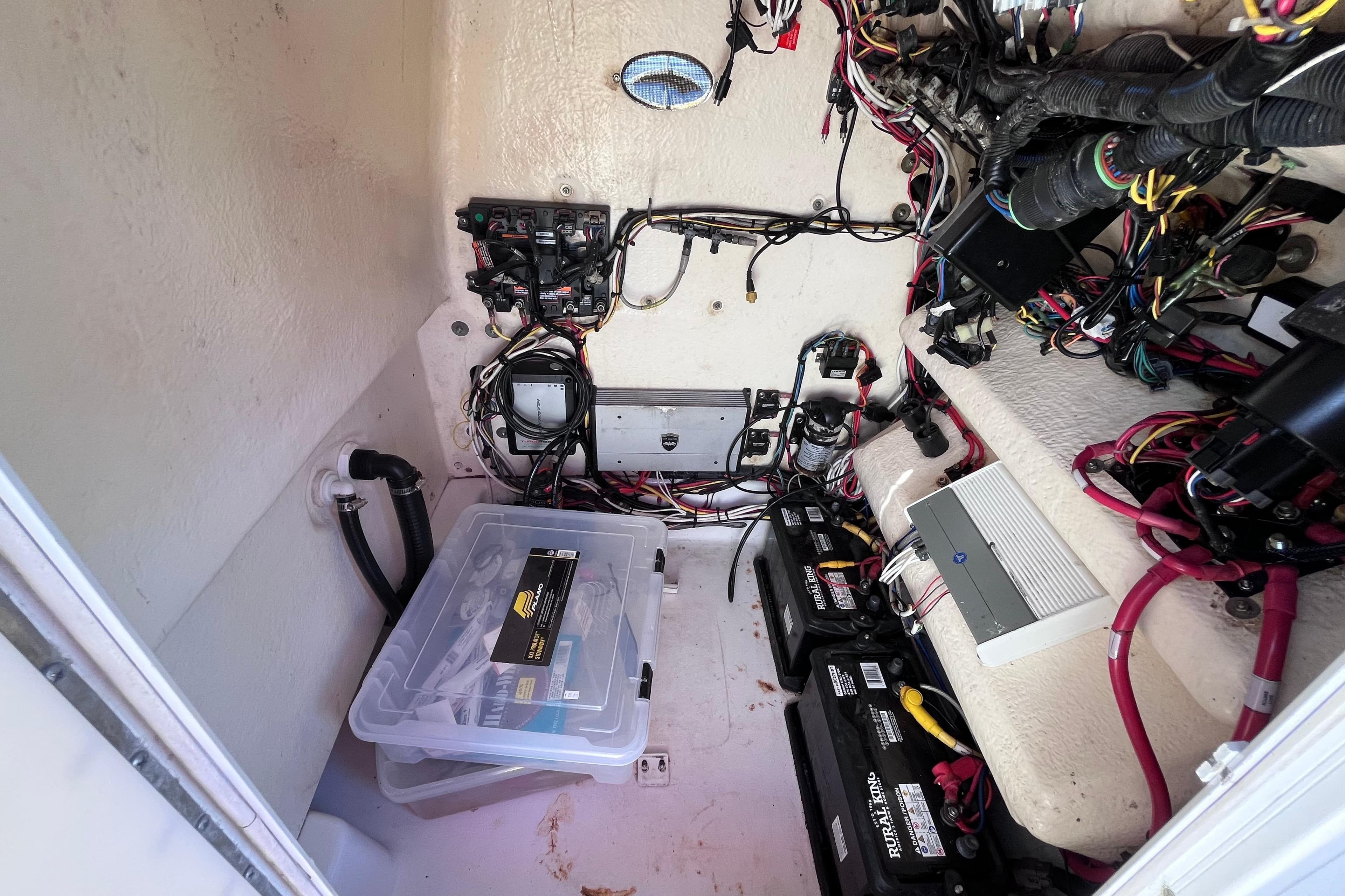 2016 Crevalle 26 Bay boat wiring and battery compartment with organized cables and storage.
