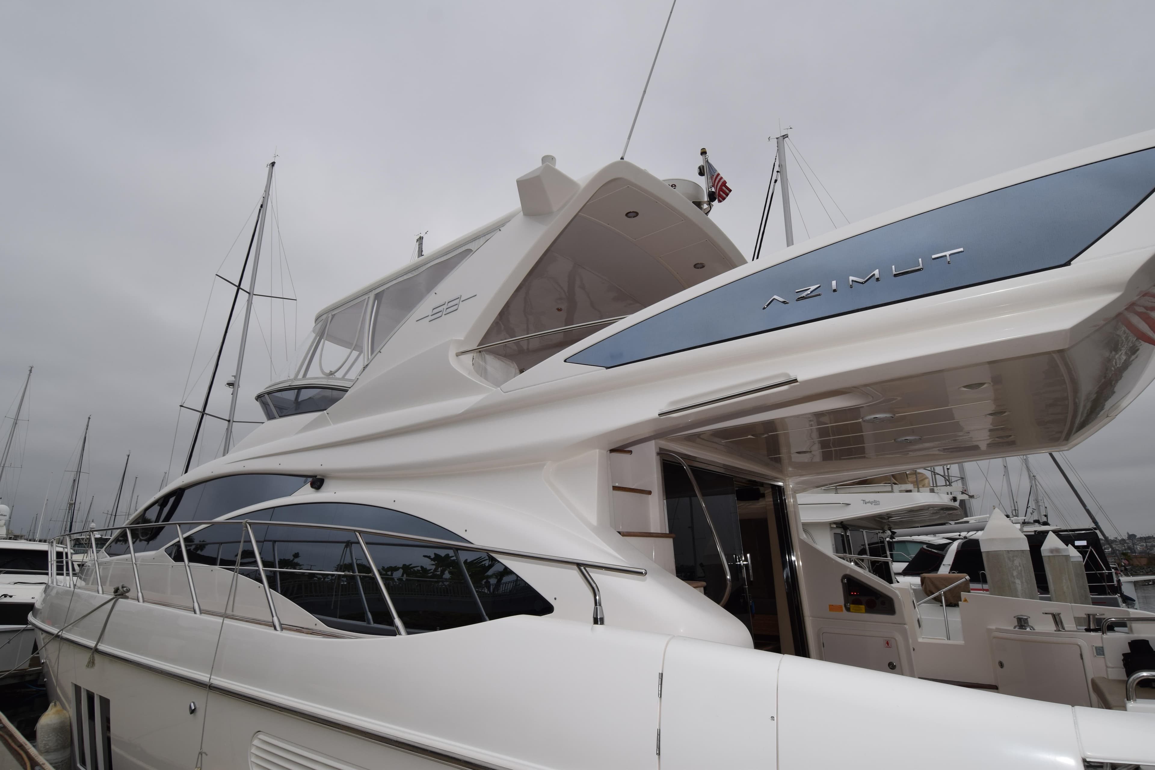 Luxury 2010 Azimut 58 yacht docked at marina, showcasing sleek design and spacious deck.