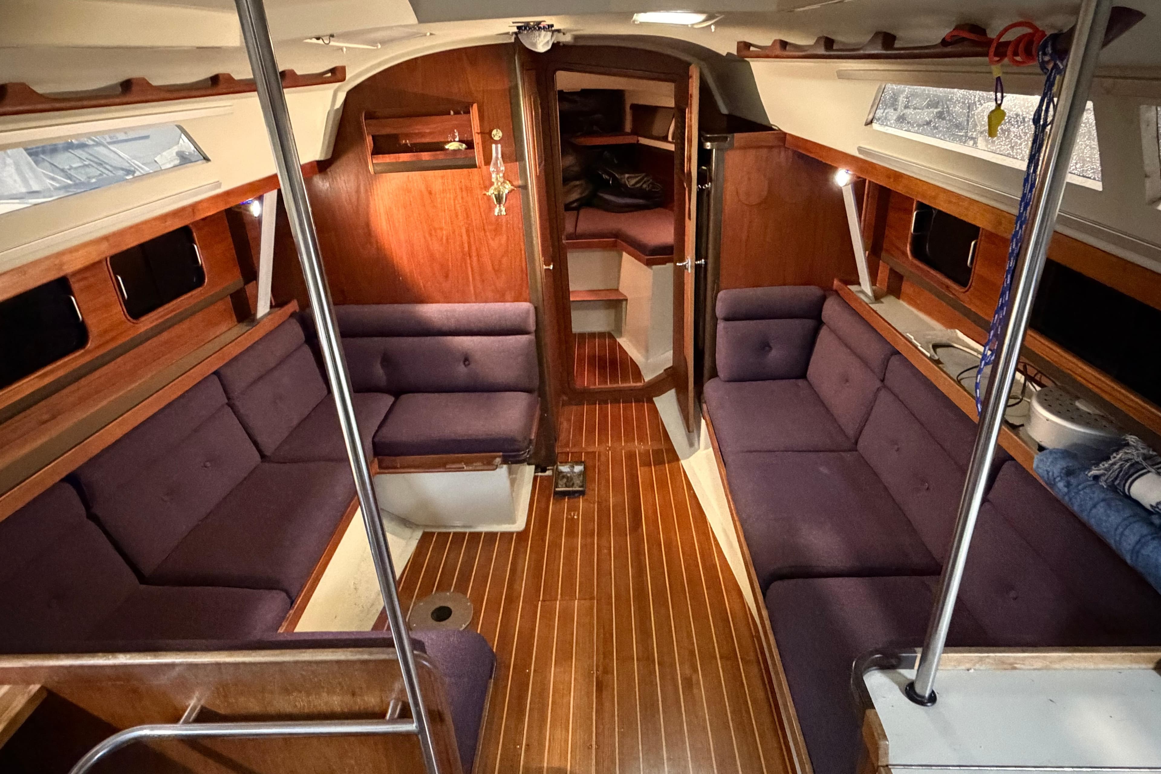 Interior of 1985 C&C 35 MK III sailboat with wood paneling and purple seating.