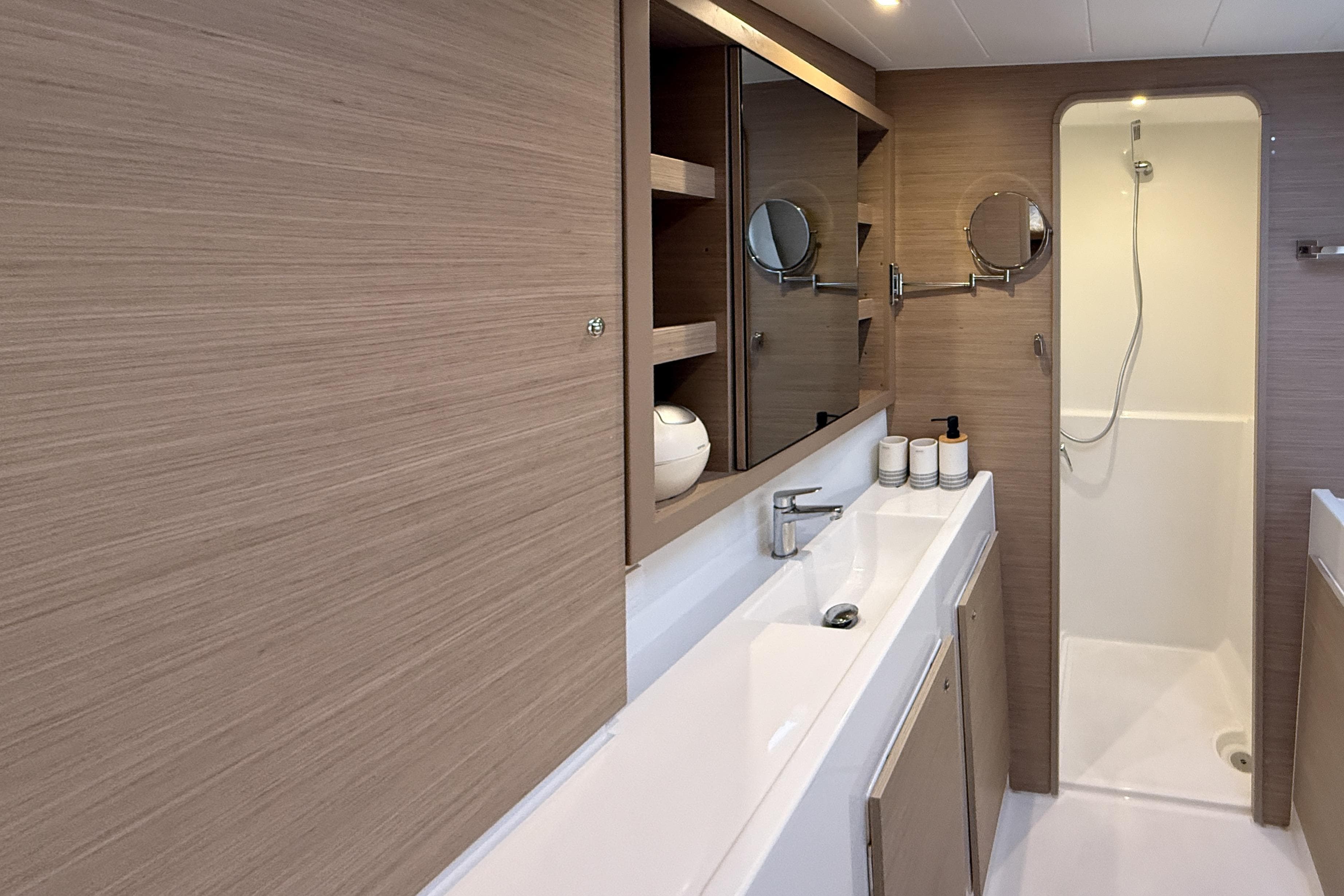 Modern bathroom interior of 2024 Lagoon 42 yacht with sleek design and wooden accents.