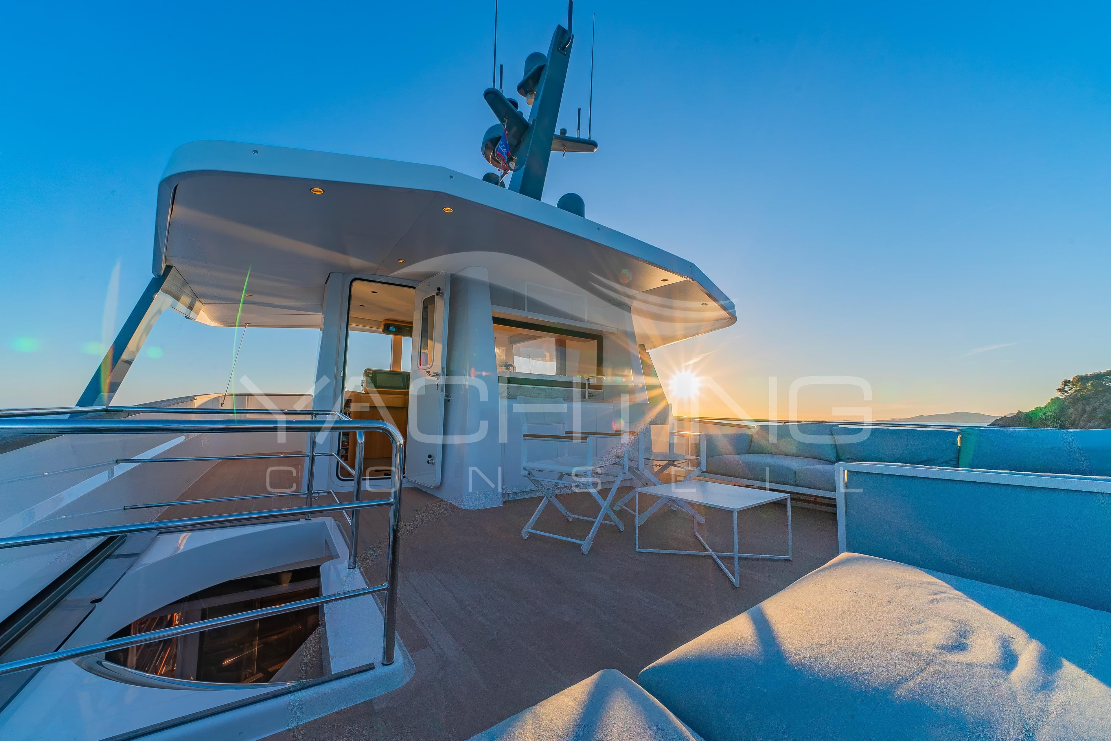 Luxurious 2022 JFA Yachts Long Island 78 deck at sunset, featuring modern seating and sleek design.