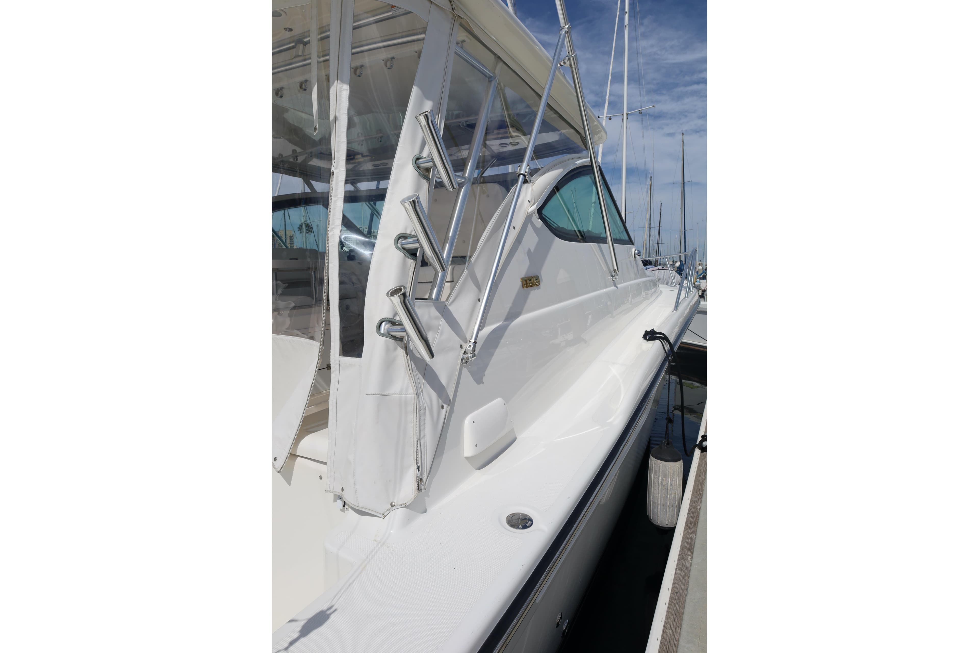 2007 Tiara 4200 Open yacht docked, showcasing sleek white exterior and fishing rod holders.