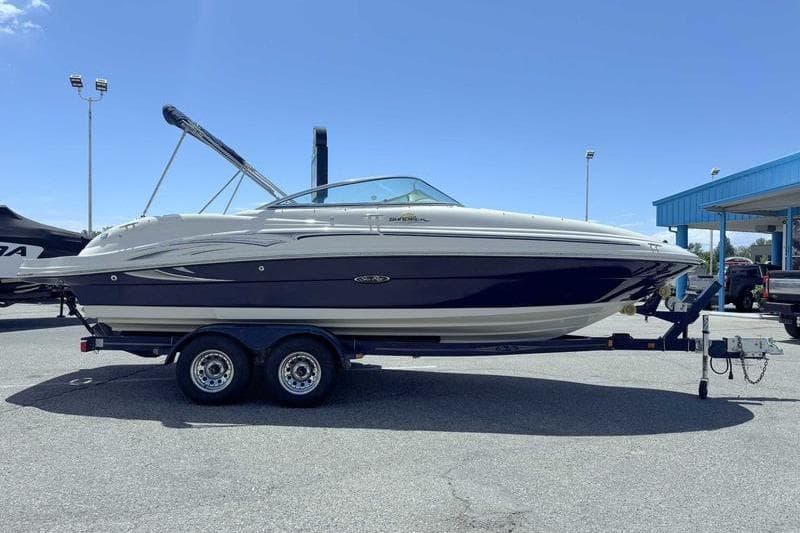 2005 Sea Ray 220 Sundeck boat on trailer under clear blue sky.