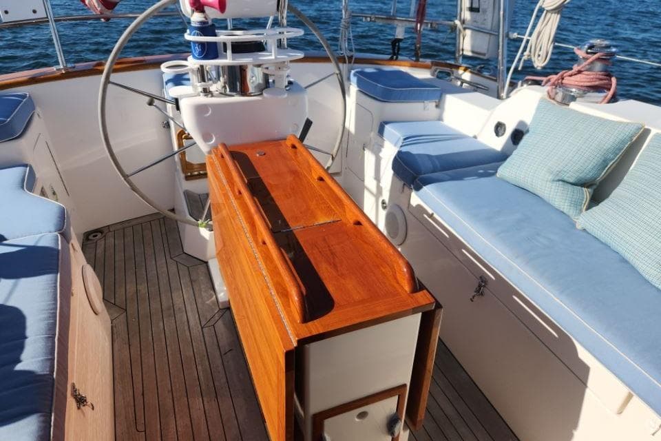 Cockpit of 2008 Bruckmann 50 MKII yacht with wooden table and cushioned seating.