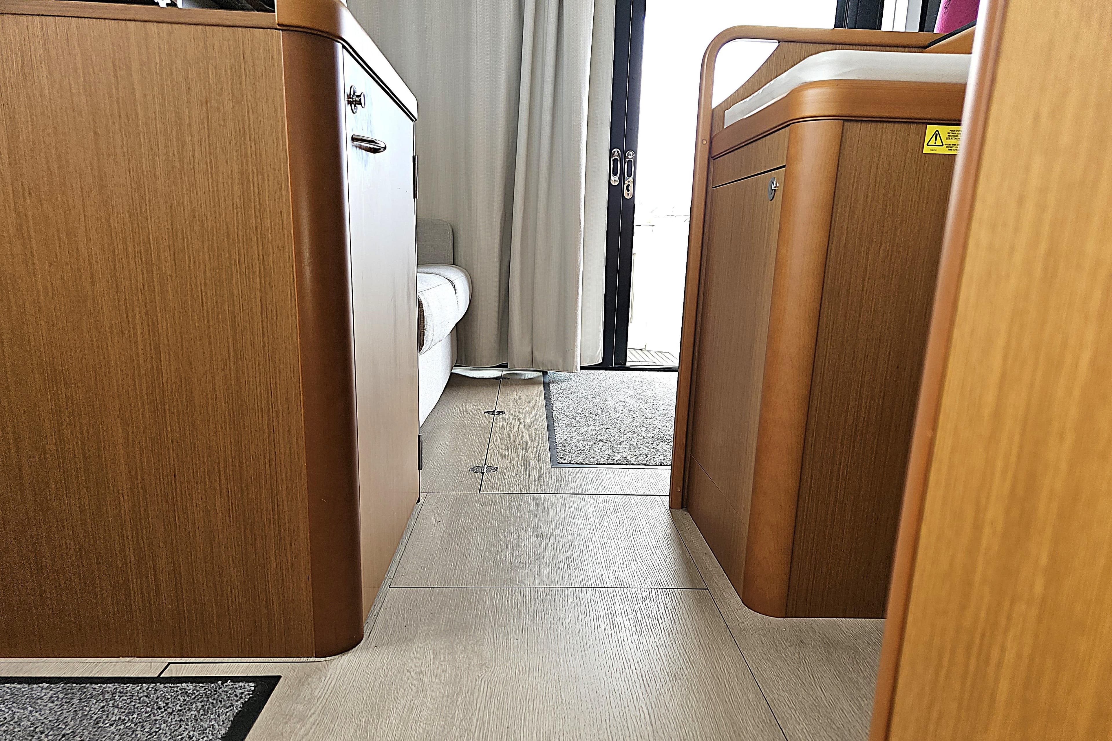 Interior view of 2018 Beneteau Swift Trawler 35, featuring wooden cabinetry and flooring.