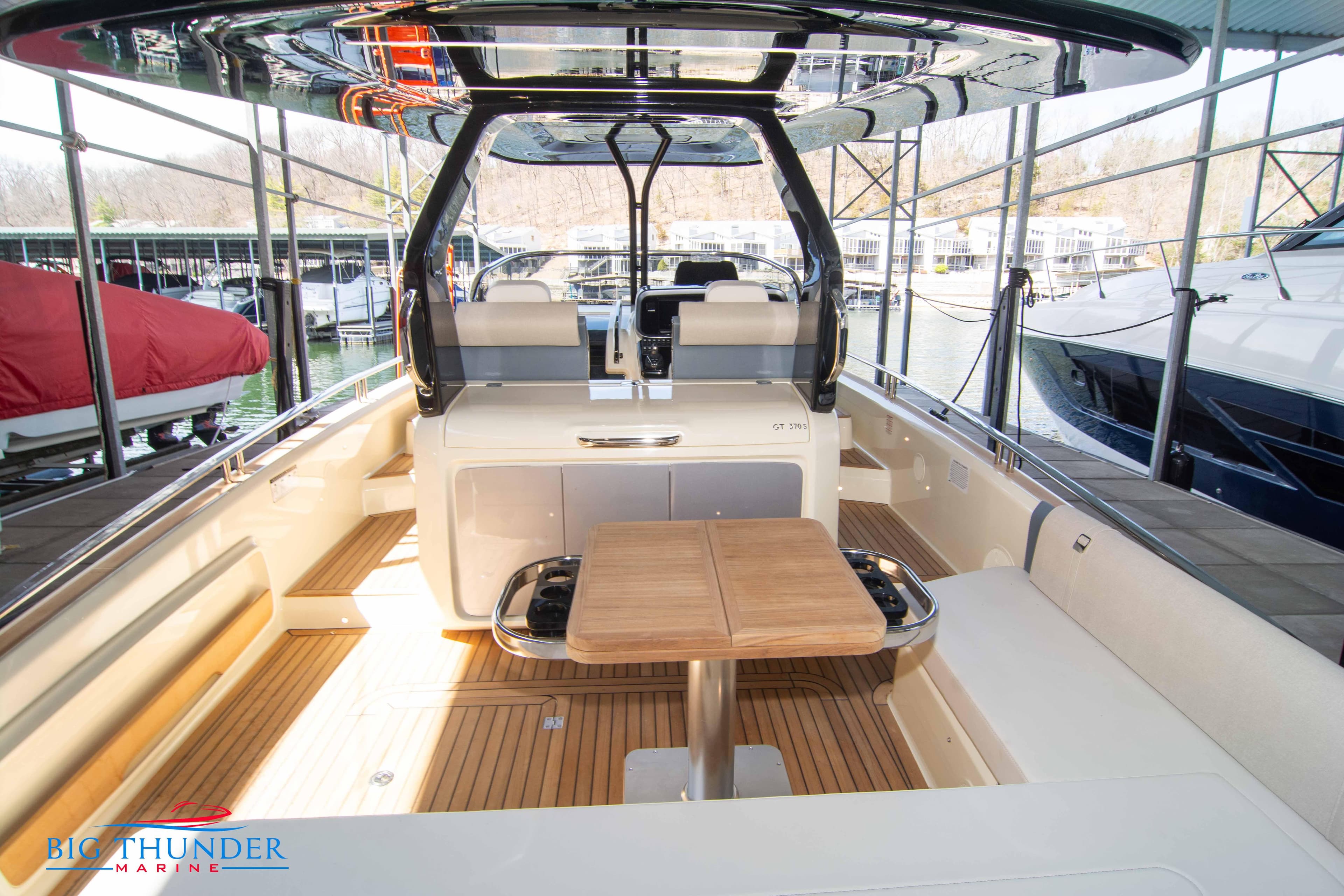 2024 Invictus GT370S luxury boat interior with wooden deck and seating area.