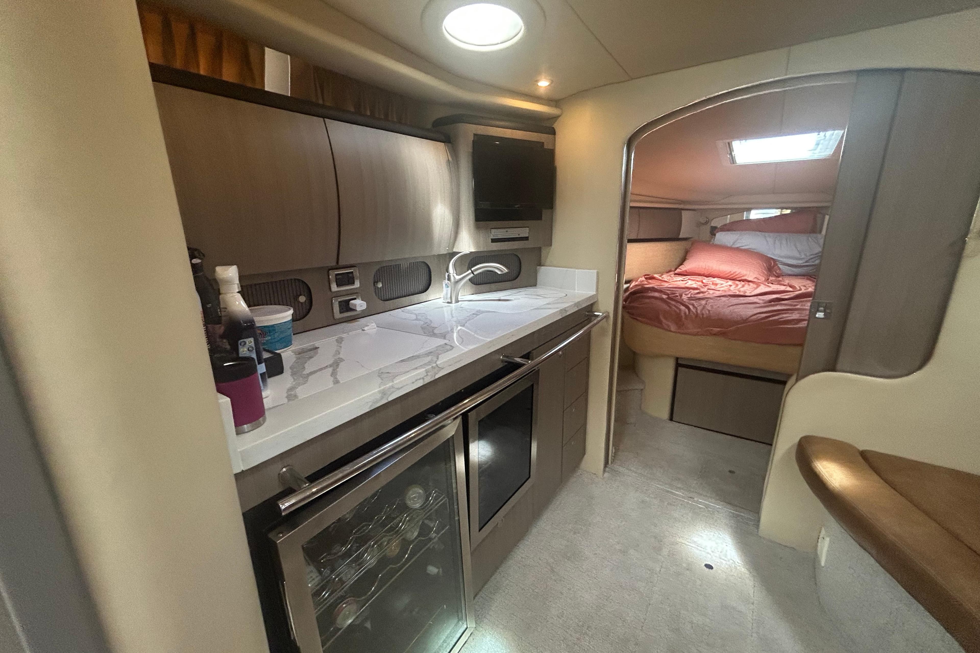 Interior of 2005 Sea Ray 360 Sundancer yacht, featuring kitchenette and cozy sleeping area.
