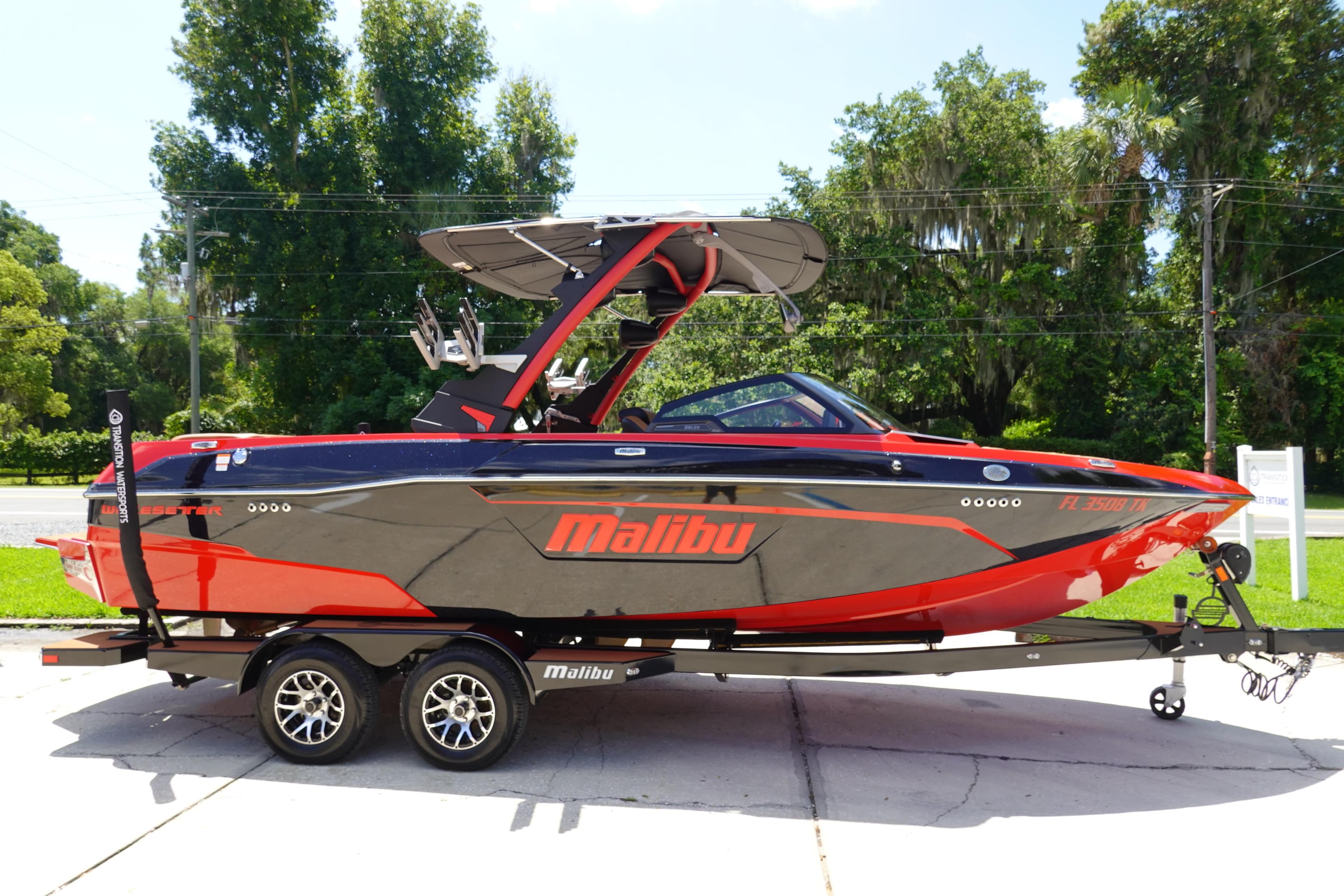2023 Malibu 23 LSV boat in black and red on a trailer.
