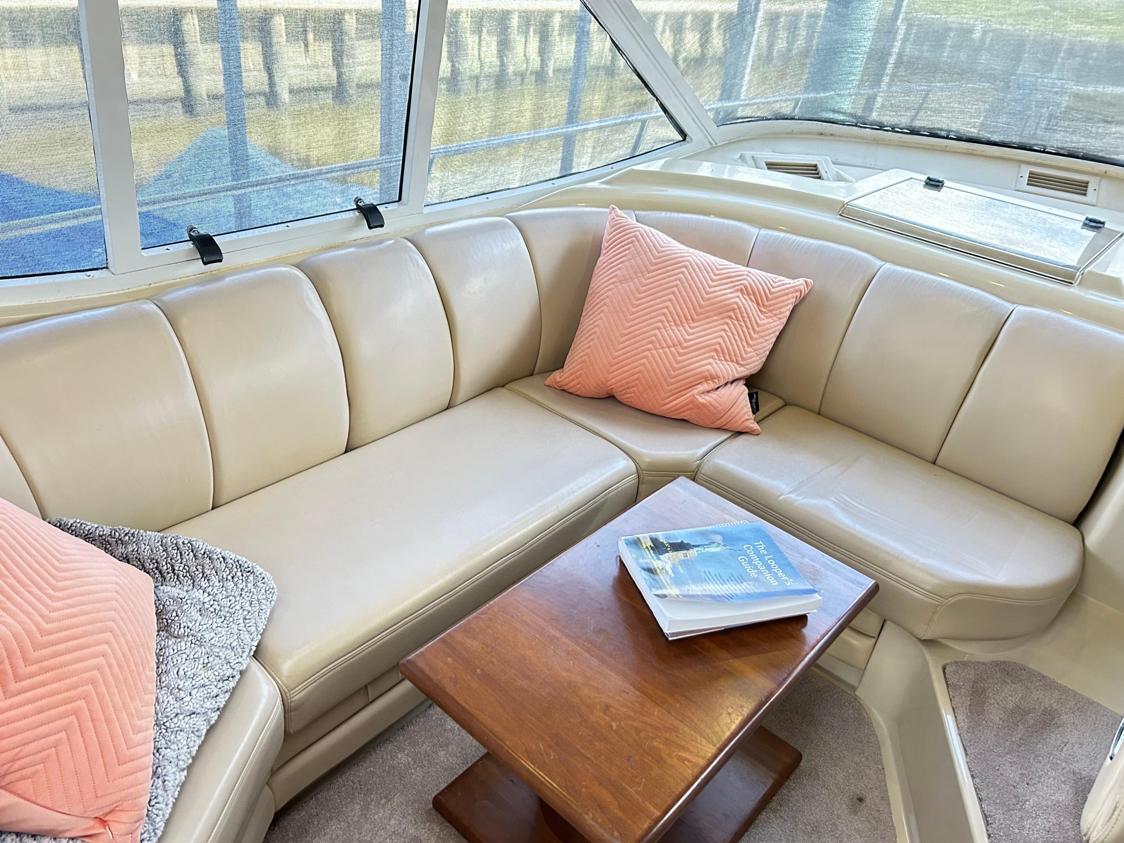 Luxurious 2004 Cruisers Yachts 5000 Sedan Sport interior with beige seating and wooden table.