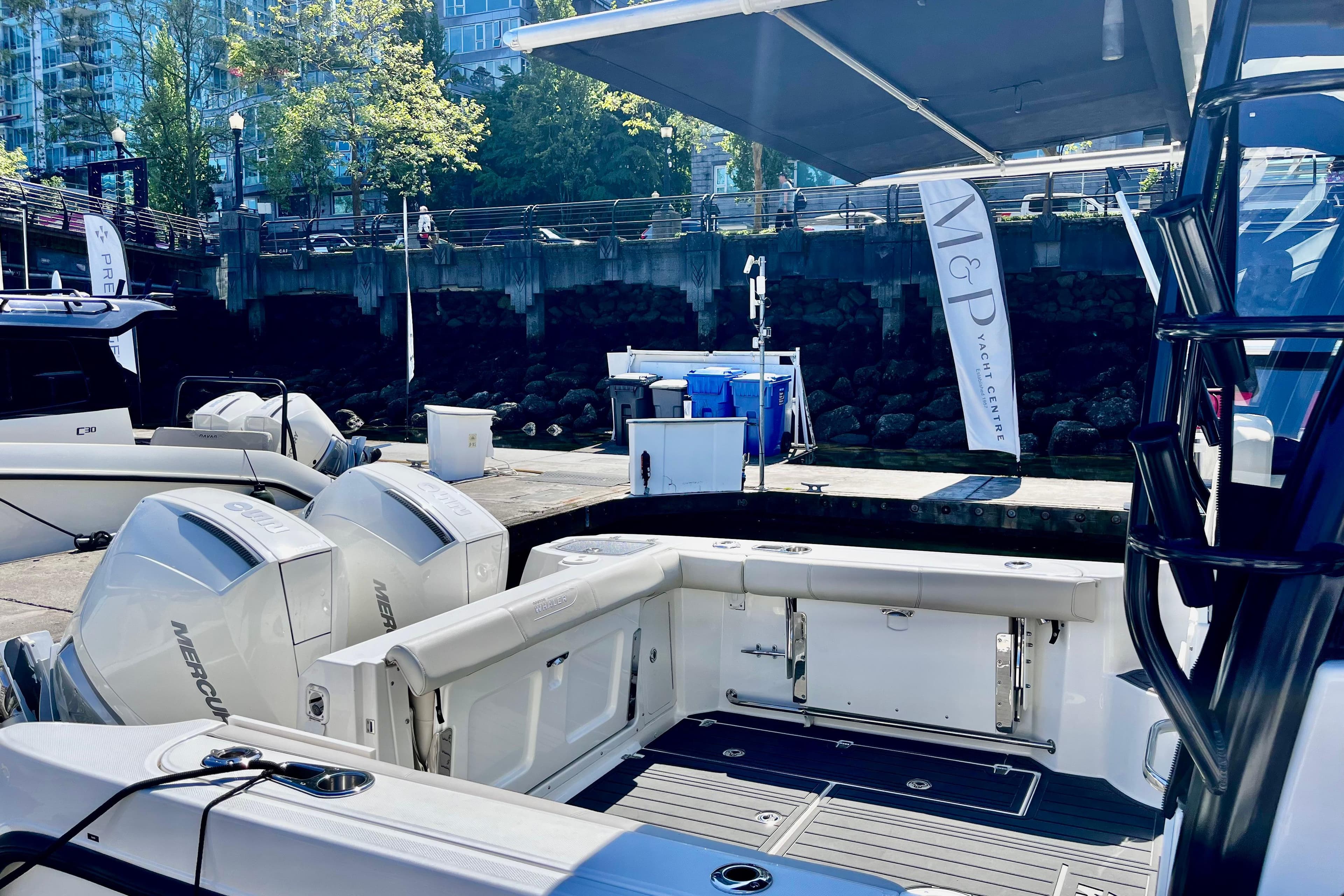 2023 Boston Whaler 285 Conquest docked, showcasing spacious deck and powerful Mercury engines.