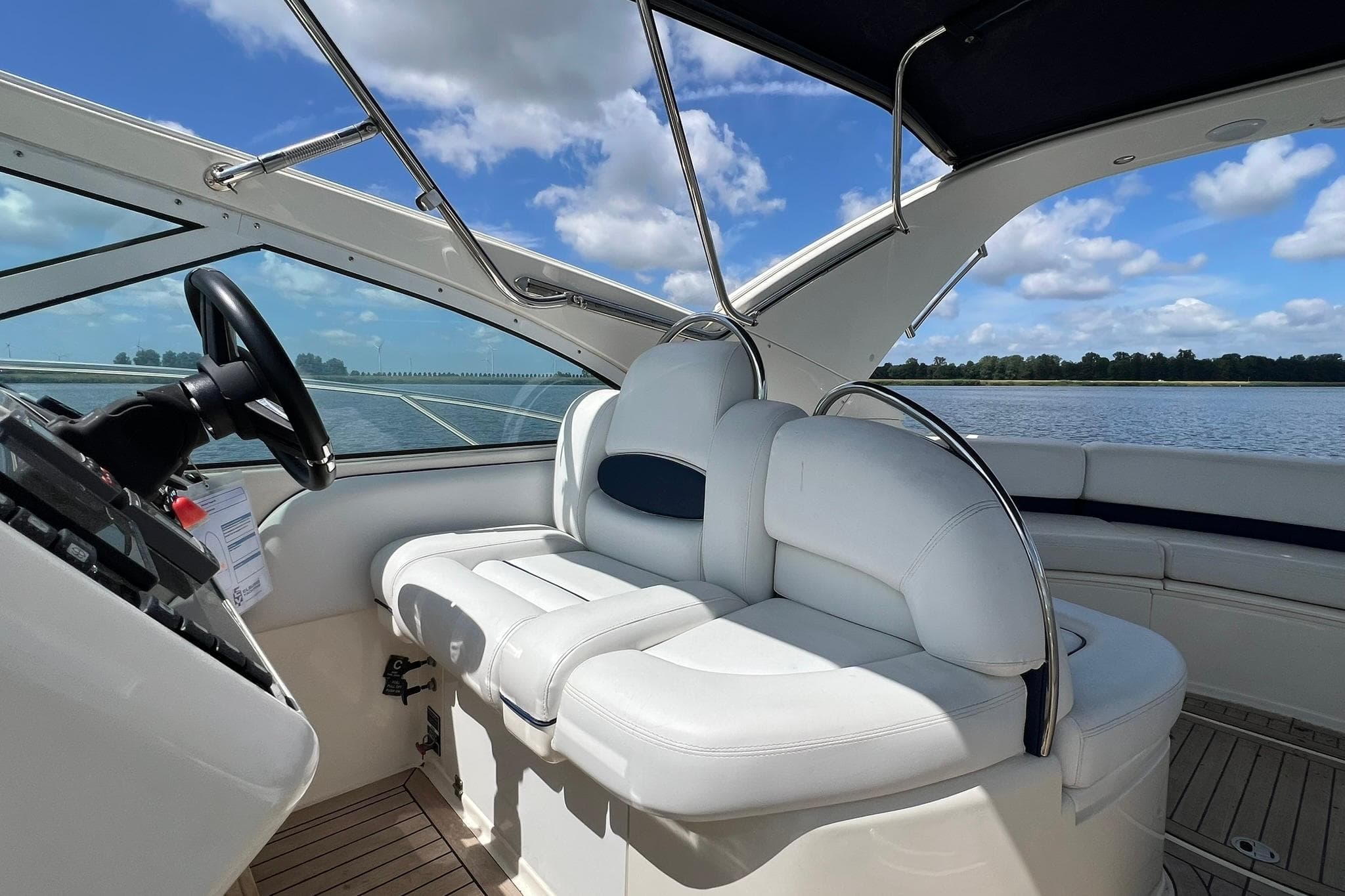 Interior of 2002 Fairline Targa 43 yacht with white seating and scenic water view.