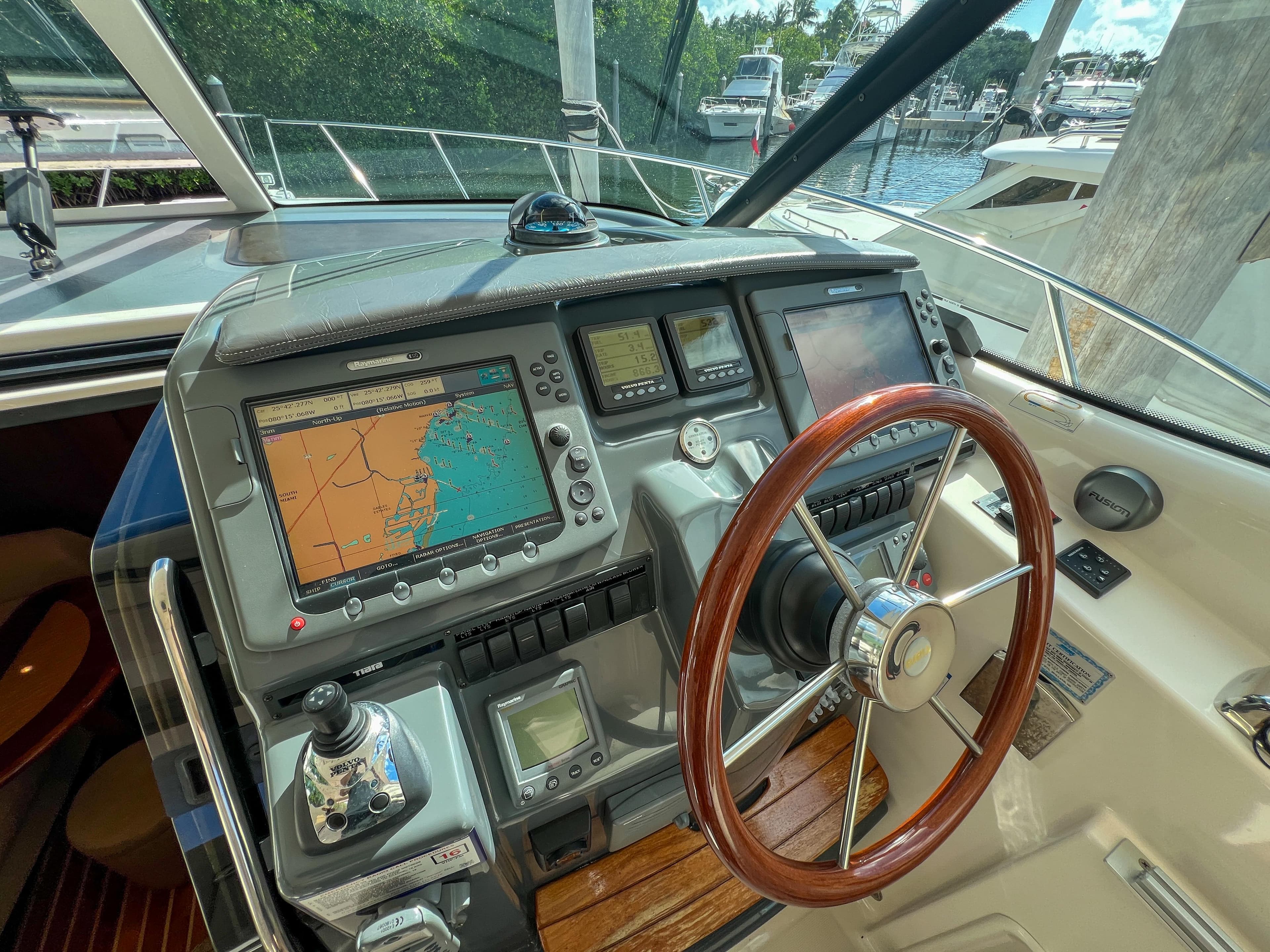 2008 Tiara Yachts 3900 Sovran helm with navigation screens and wooden steering wheel.