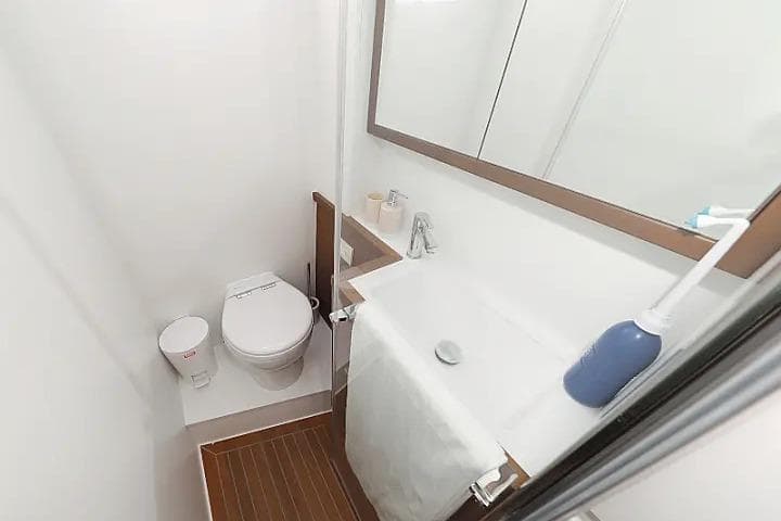 Compact bathroom in 2018 Lagoon 620 Esense yacht with modern fixtures and wooden flooring.