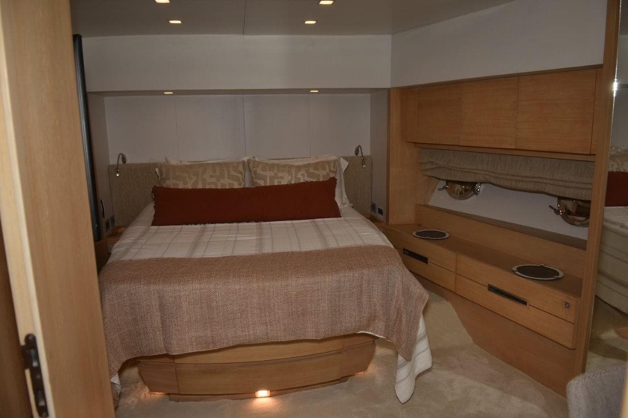Luxurious bedroom interior of 2007 Azimut 86S yacht with elegant wood furnishings.