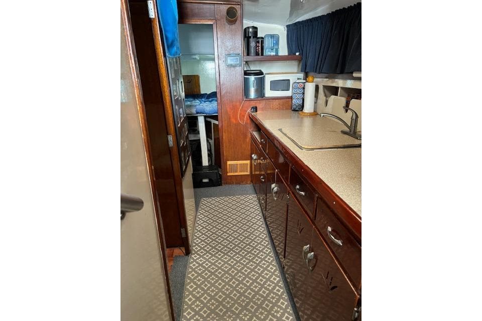Interior of a 1961 Hatteras 41 Convertible yacht with wooden cabinetry and kitchenette.