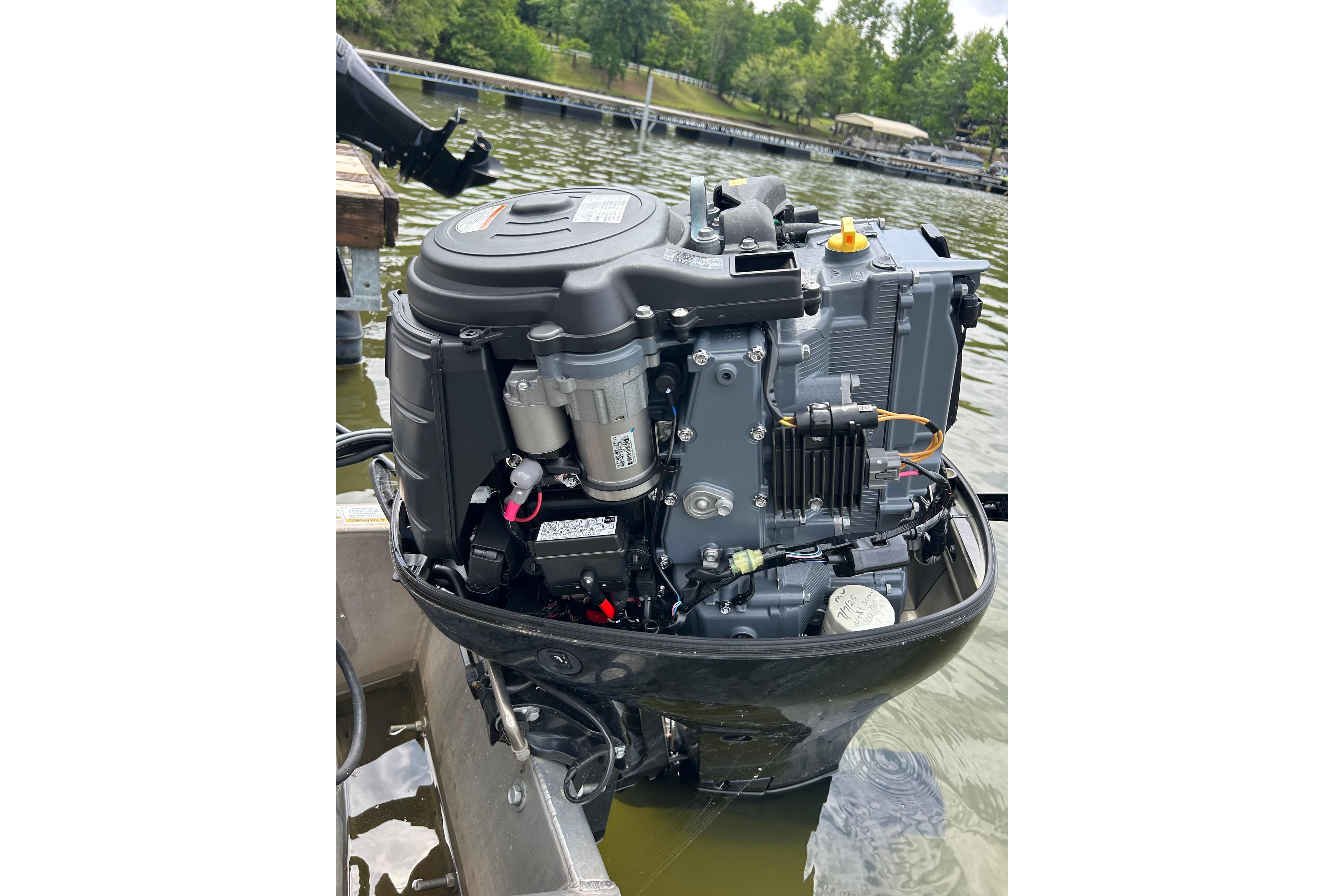 Outboard motor of a 2025 Southbay 224RSLE25 boat on a lake.