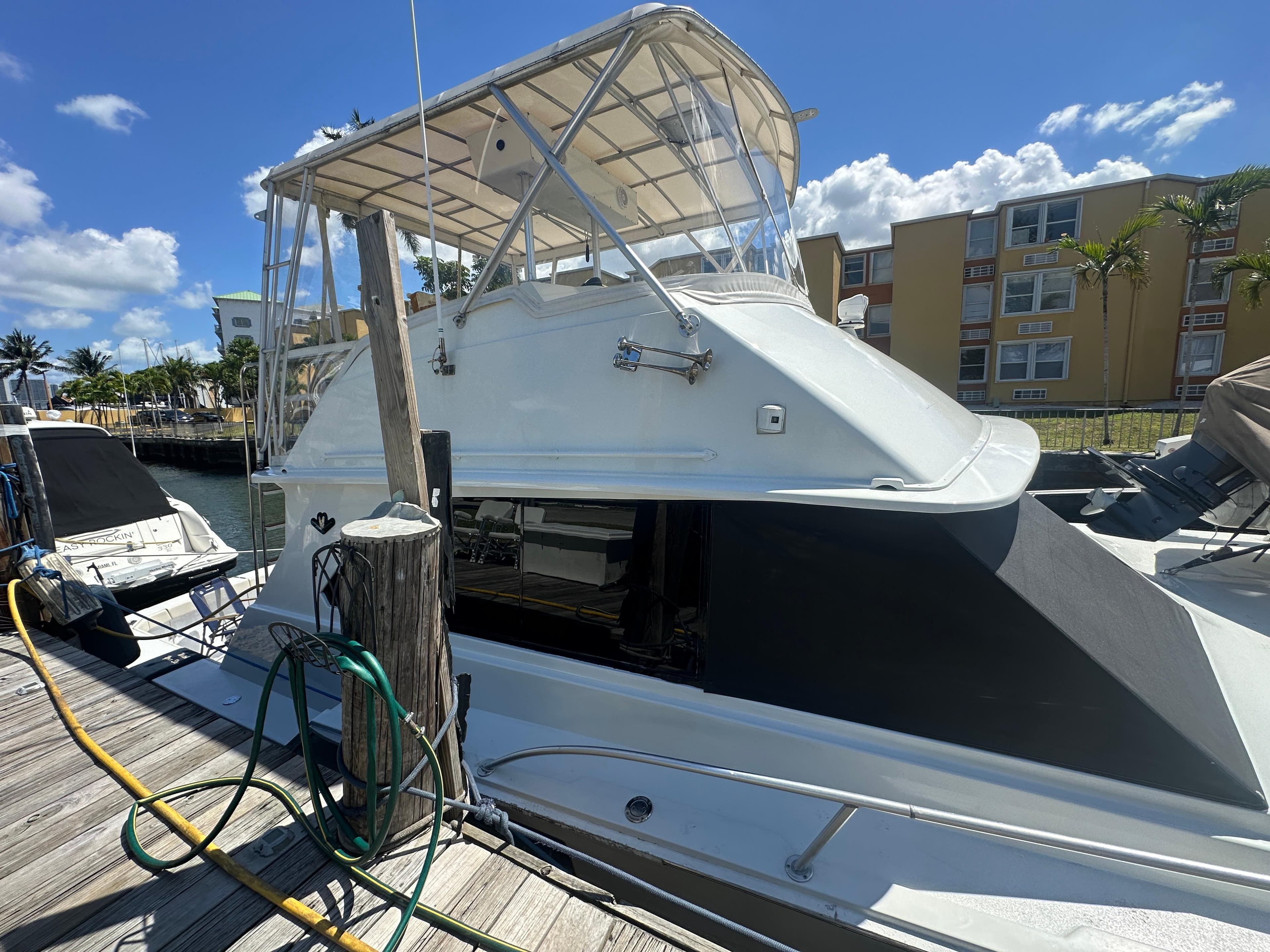 1985 Bertram 46 Convertible yacht docked under clear blue sky.