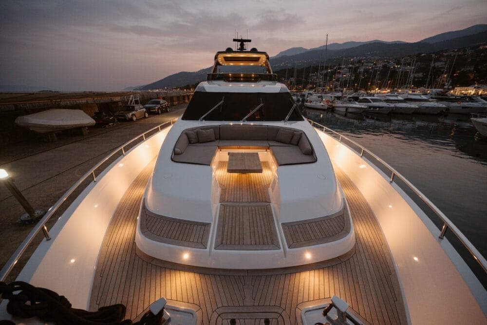 Sanlorenzo SL86 2016 yacht at sunset, docked in a marina with elegant deck lighting.