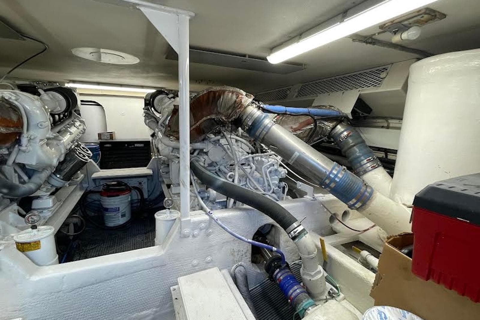 Engine room of a 1990 Viking 53 Convertible yacht, showcasing dual engines and piping.