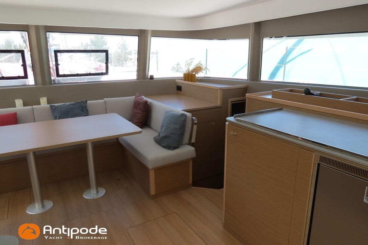 Modern interior of 2023 Excess 14 yacht with dining area and kitchenette.