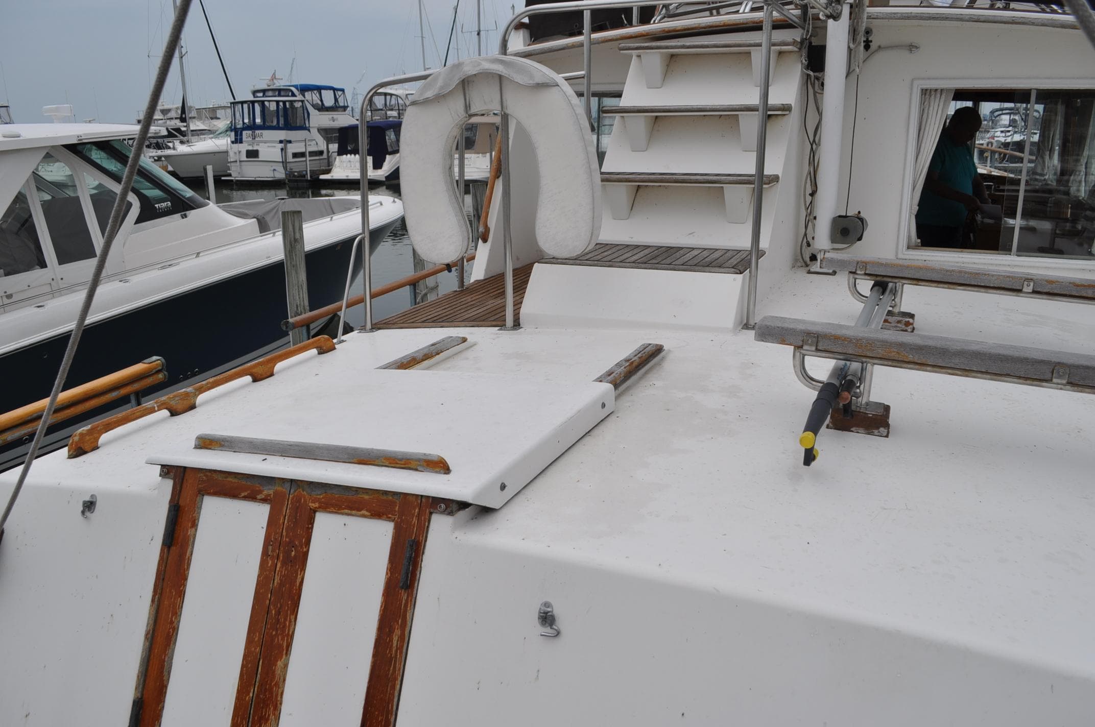 1983 Grand Banks 42 Classic yacht deck with life preserver and docked boats.
