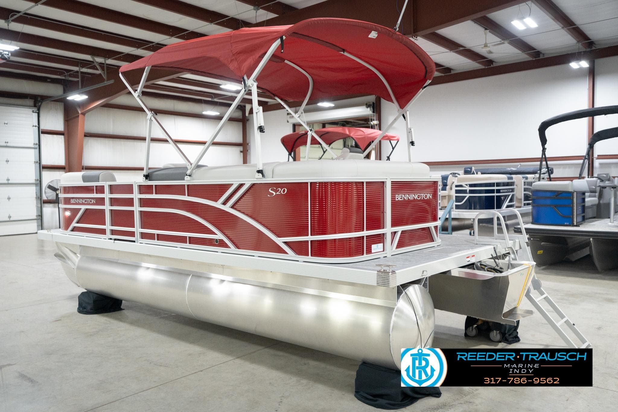 2026 Bennington 20 SL pontoon boat with red canopy in a showroom.