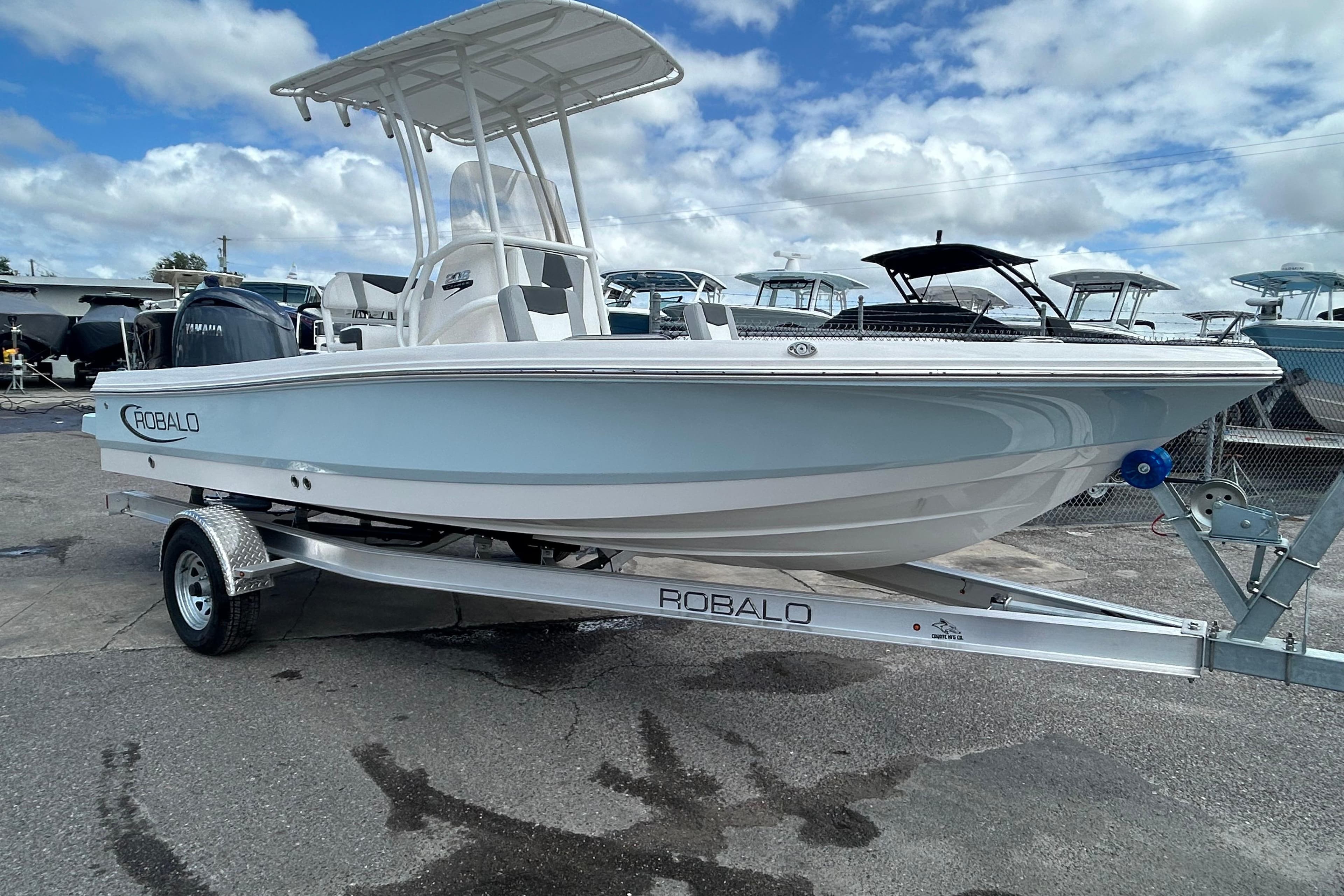 2026 Robalo 206 Cayman boat on trailer under cloudy sky.