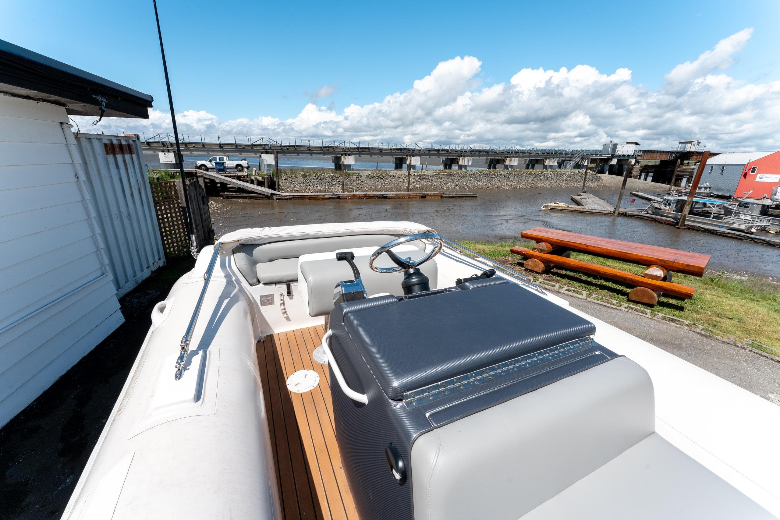 2007 Nautica RIB 19 boat docked near a river with a scenic bridge view.
