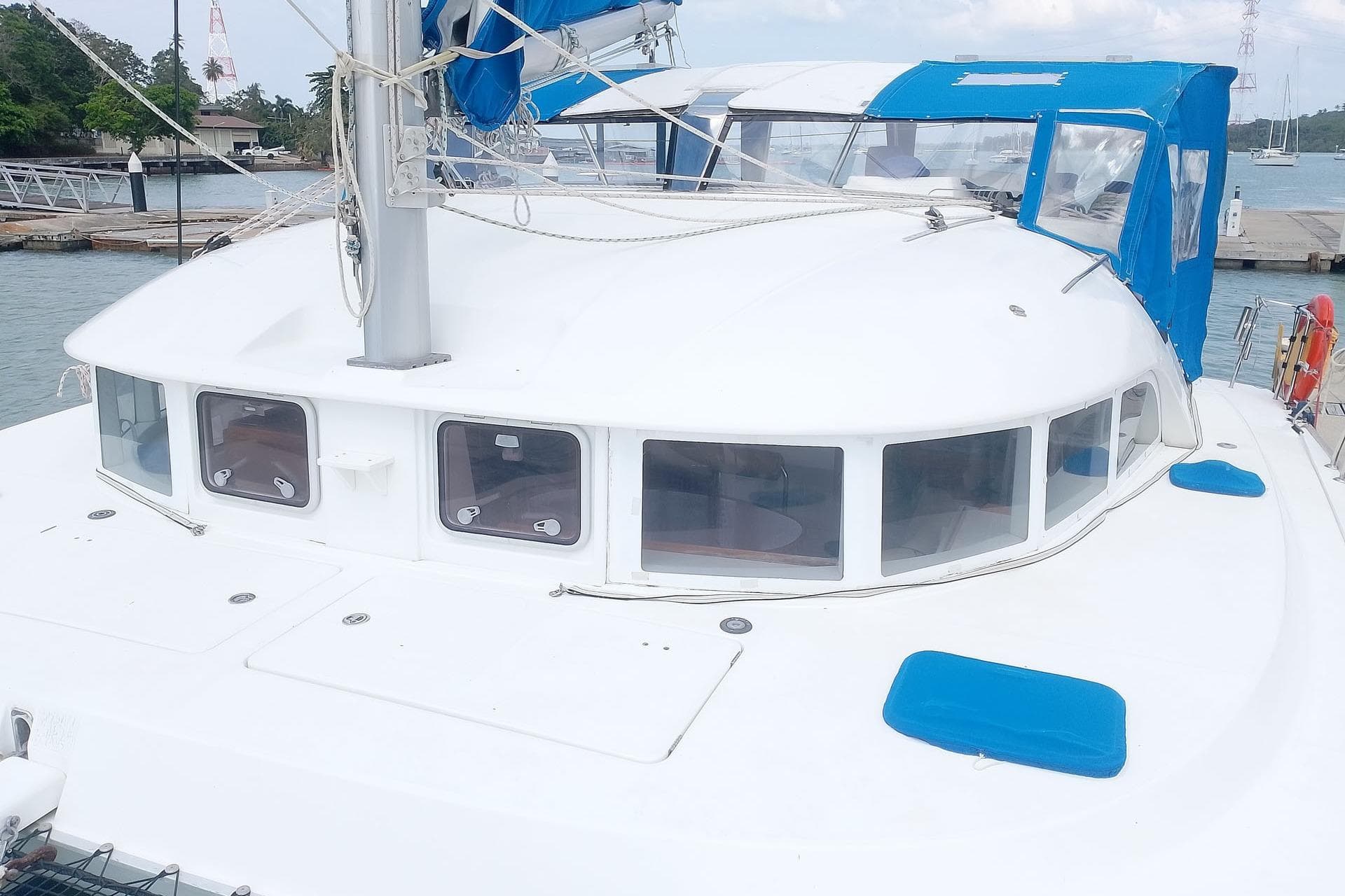 2006 Lagoon 380 S2 catamaran docked, featuring blue accents and spacious deck.