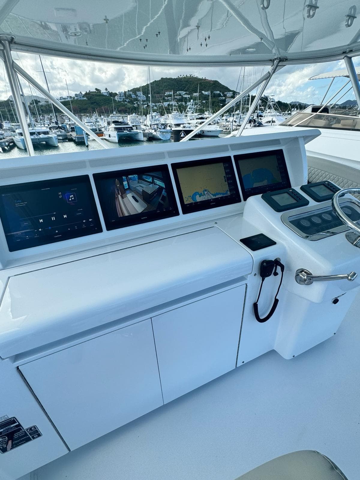 Control panel of a 2009 Hatteras 60 Convertible yacht with multiple screens and navigation equipment.