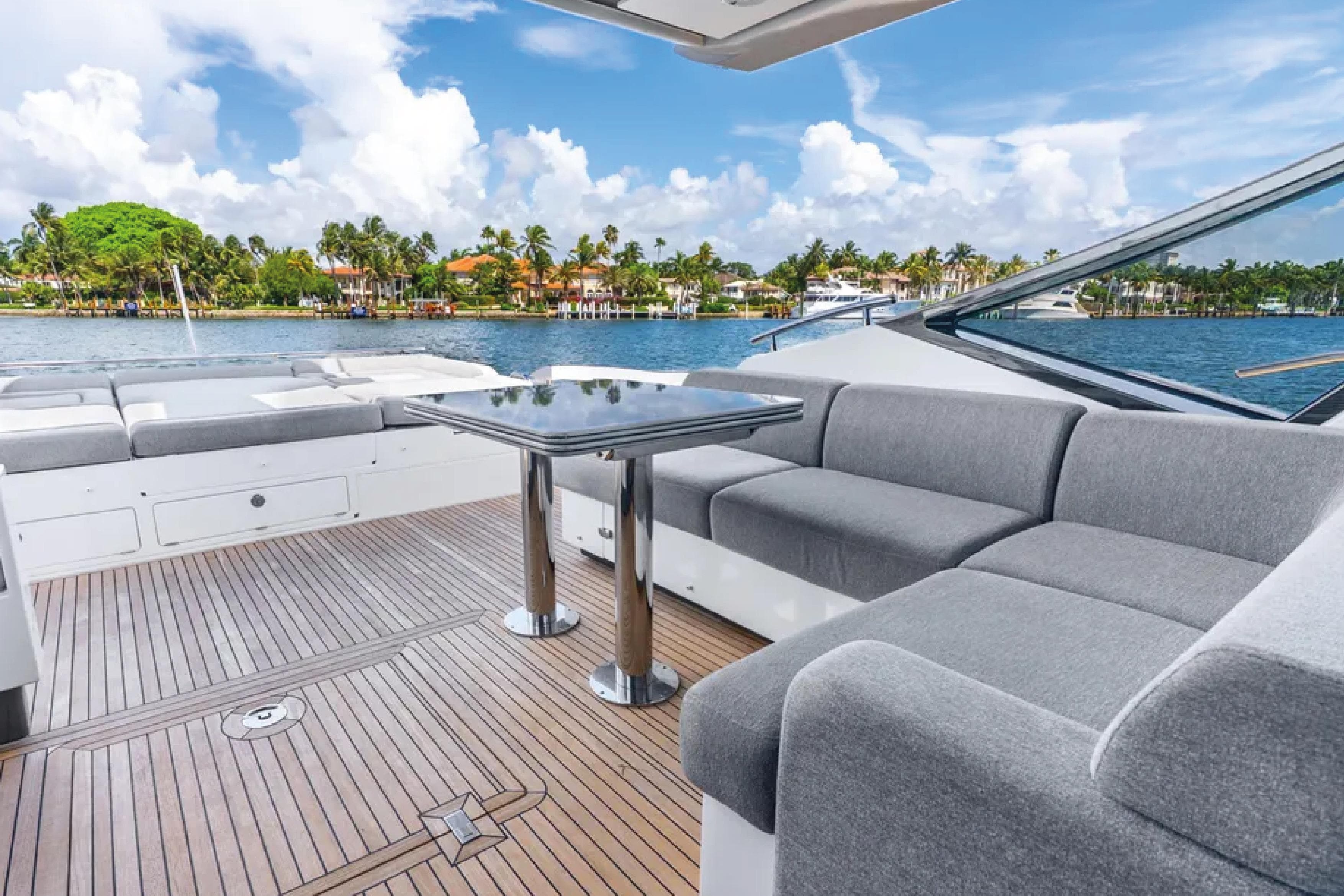 Luxurious 2019 Azimut S7 yacht deck with elegant seating and scenic waterfront view.