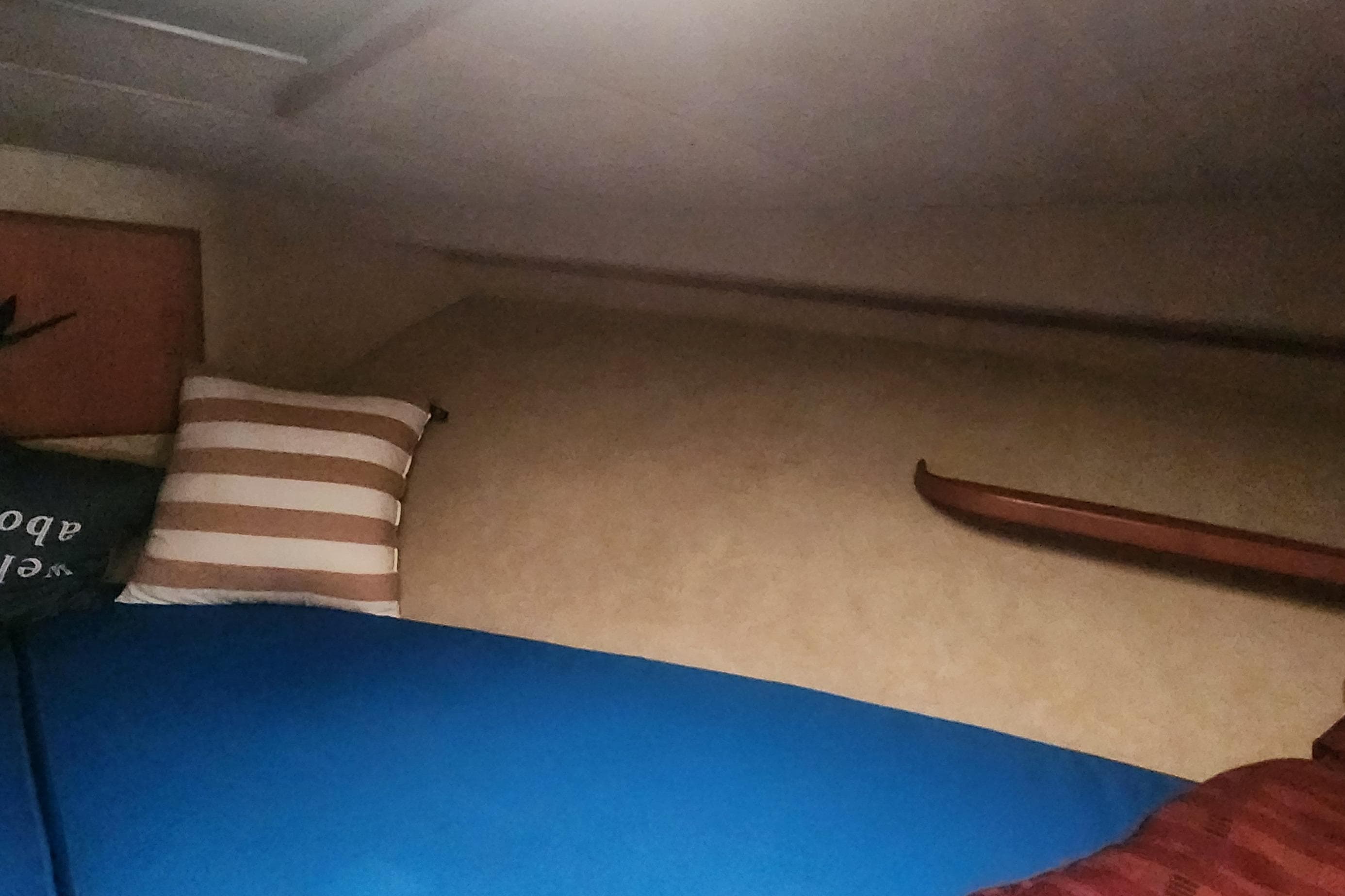 Interior cabin of 1985 Bertram 33 Flybridge Cruiser with striped pillow and blue bedding.