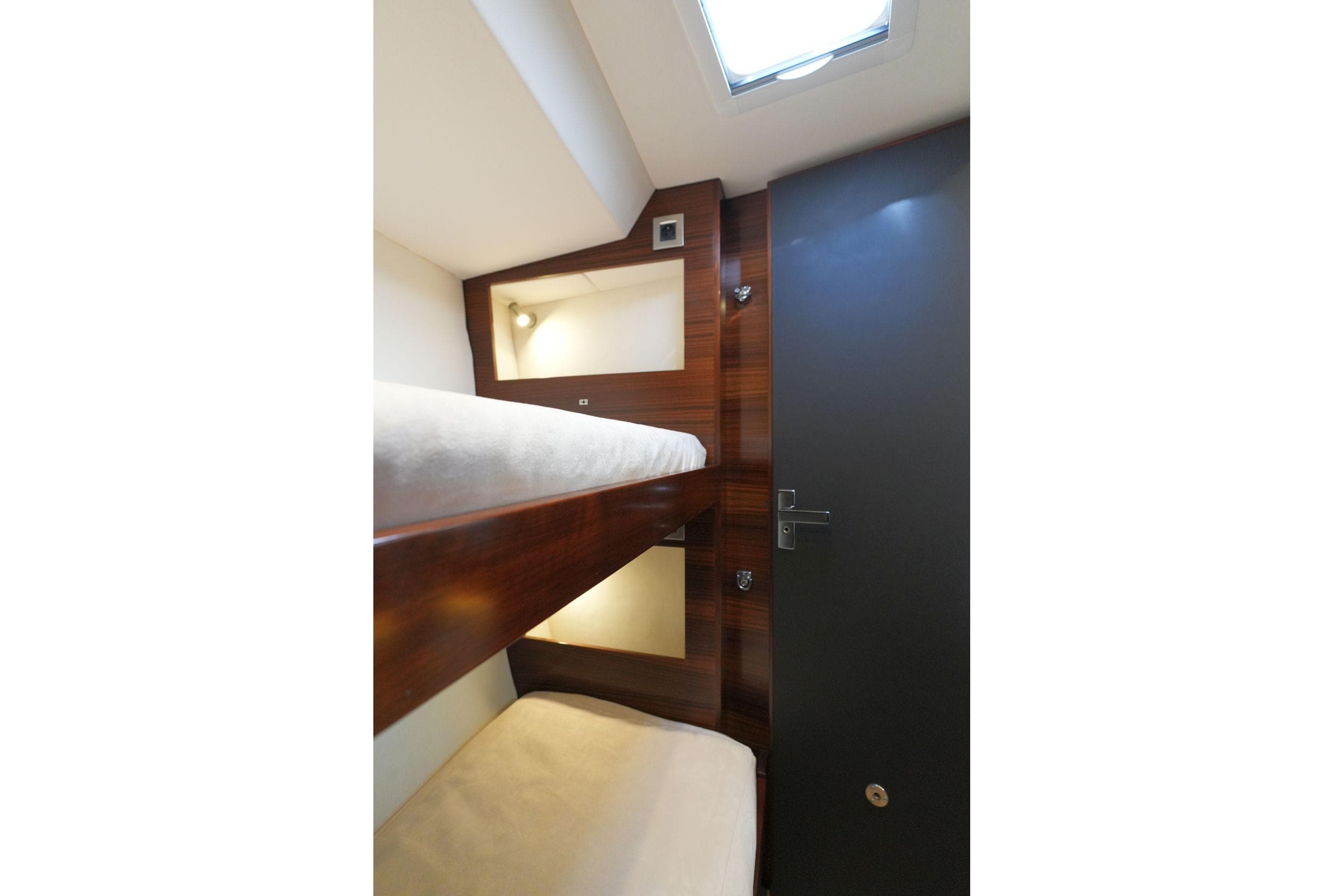 Interior of 2017 Amel 50 yacht featuring cozy bunk beds and modern wood paneling.