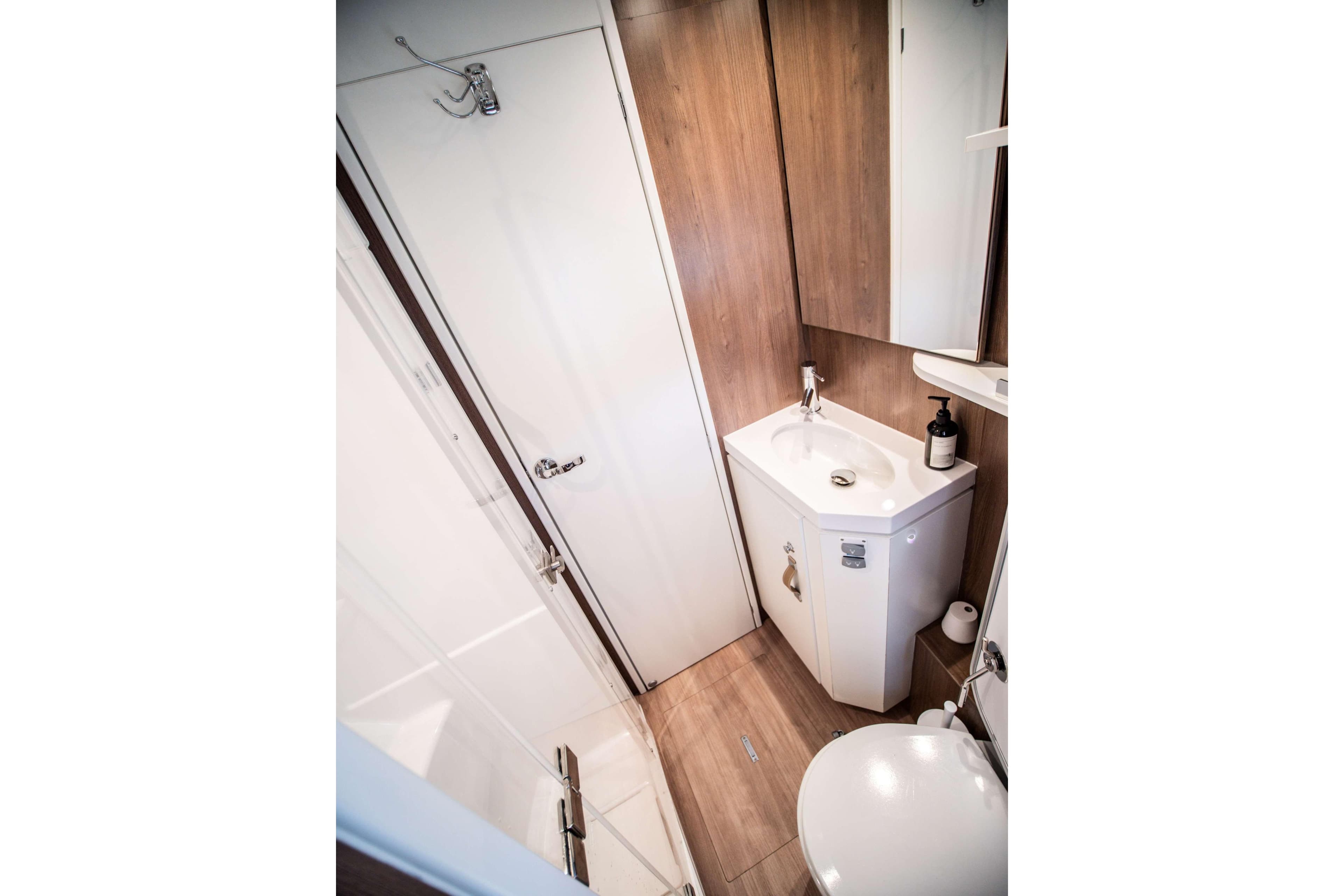 Compact bathroom in 2022 Bali 5.4 model, featuring modern fixtures and wood accents.