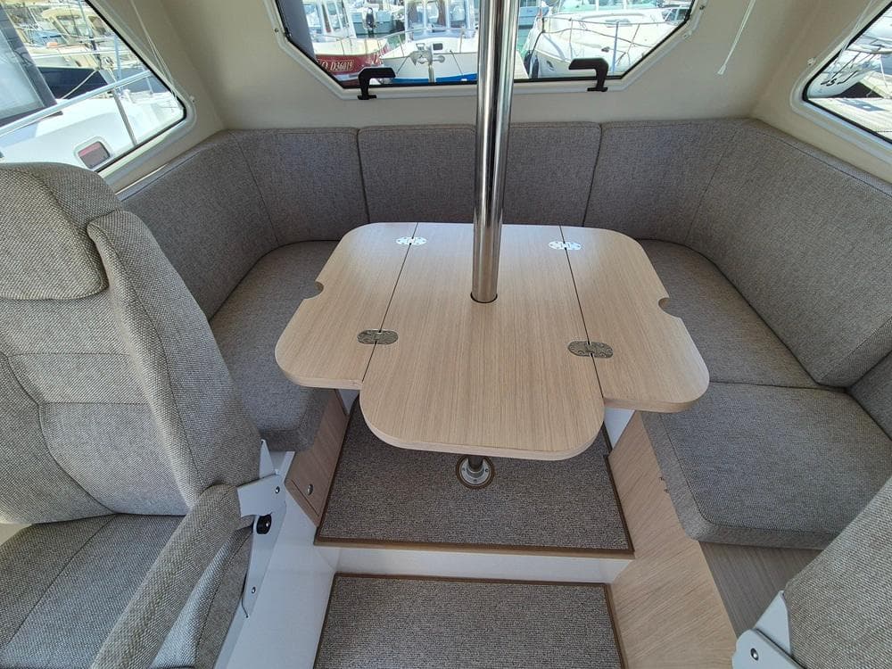 Cozy interior of 2025 Nord Star 28 Plus with cushioned seating and wooden table.