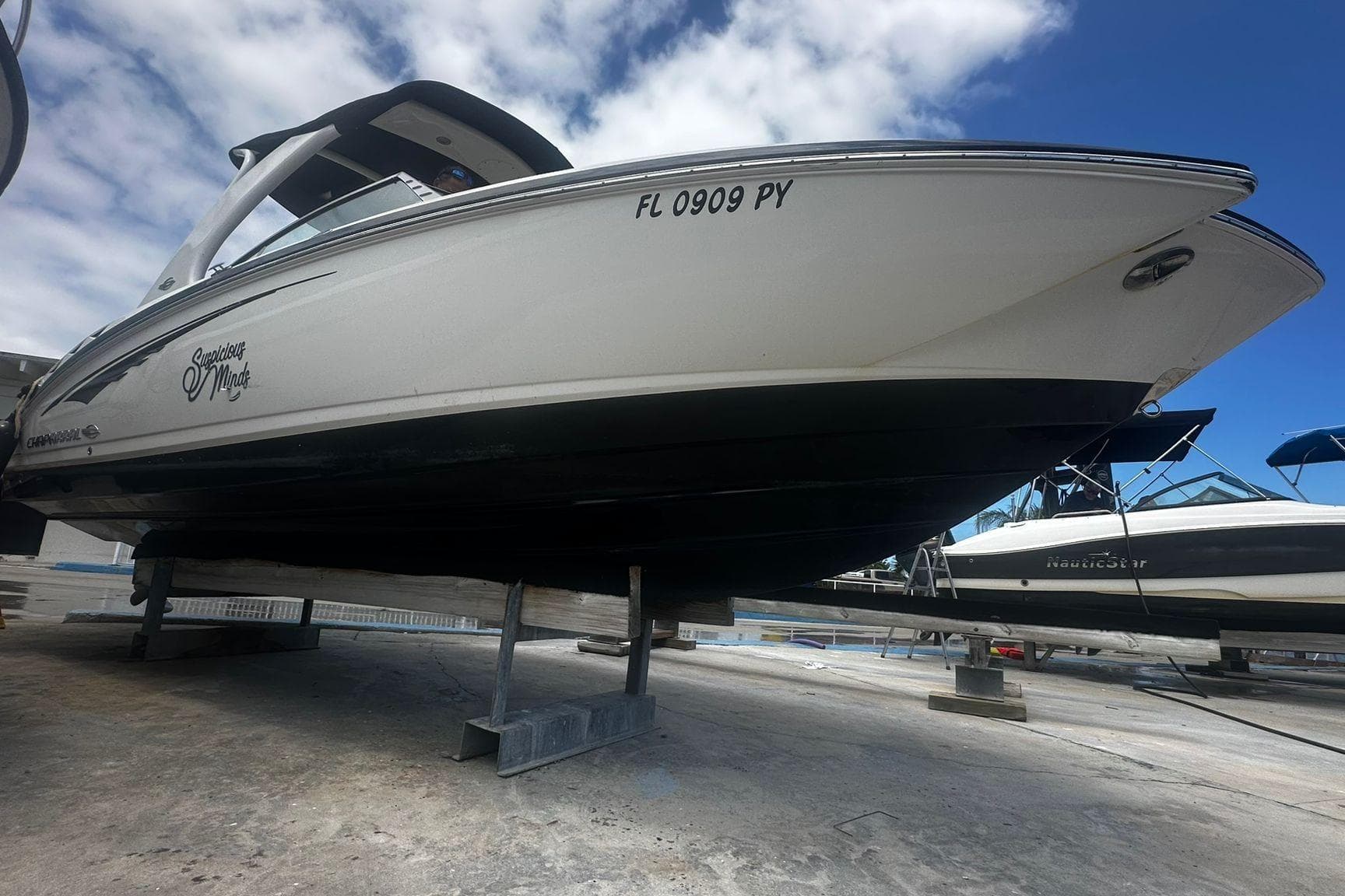 2015 Chaparral 264 Sunesta boat on dry dock under a partly cloudy sky.