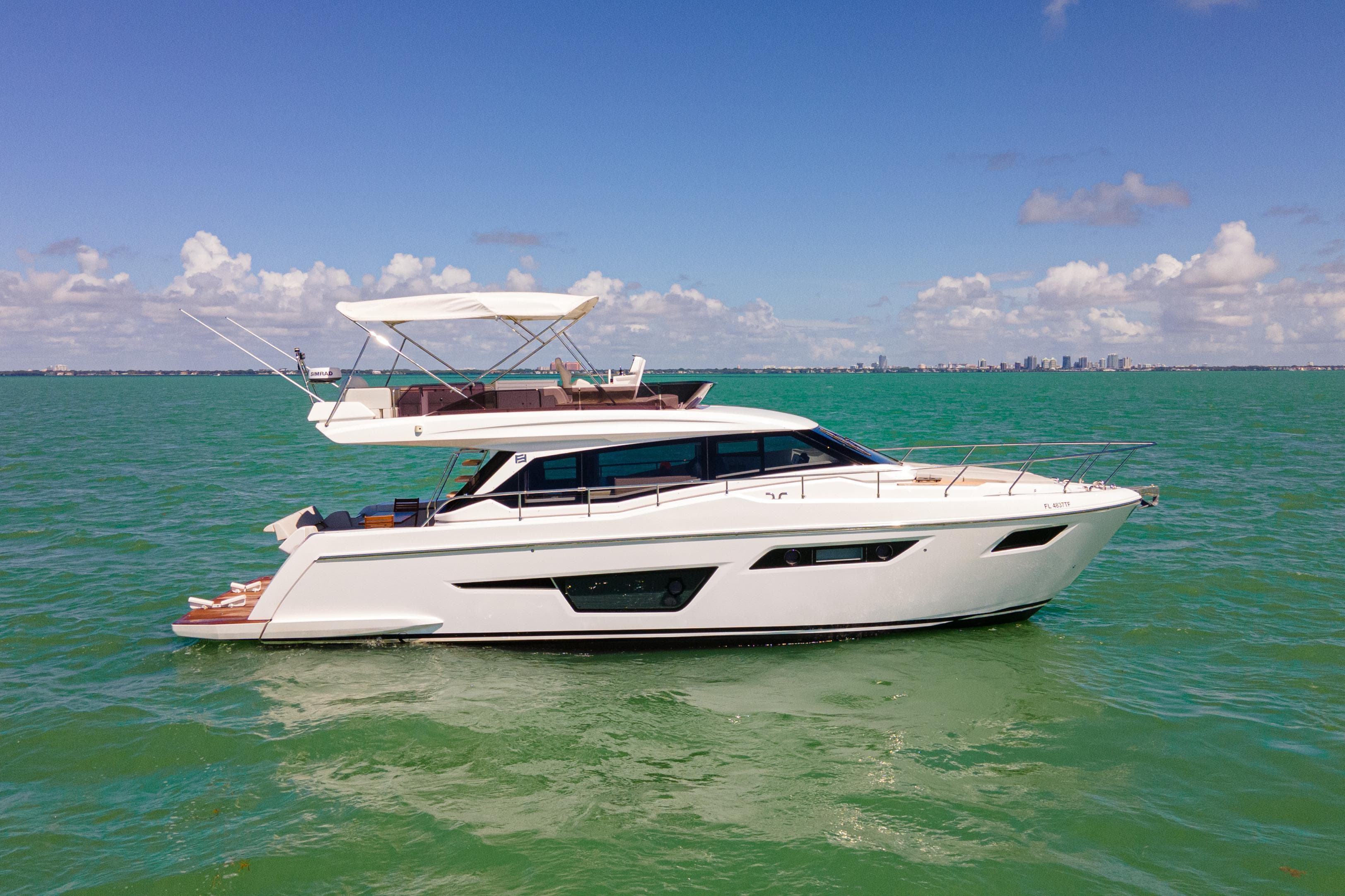 2022 Ferretti Yachts 500 cruising on calm green waters under a clear blue sky.