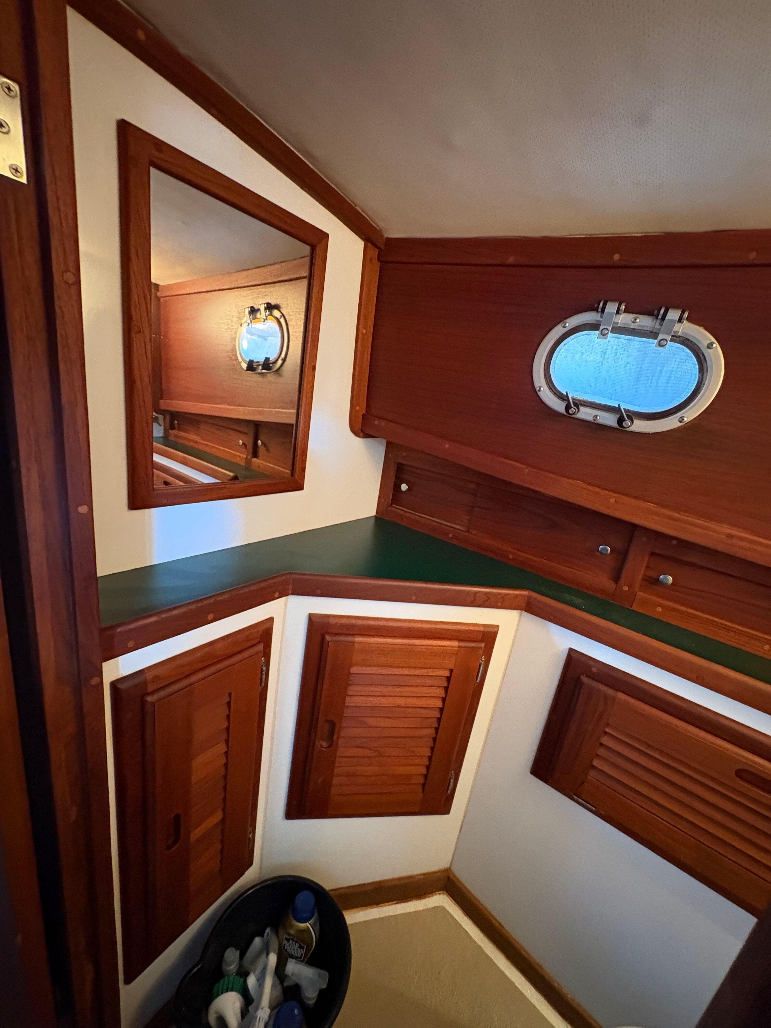 1988 Ellis Down East boat interior with wooden cabinets and porthole window.