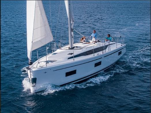 2024 Bavaria C42 sailboat cruising on open sea with passengers onboard.