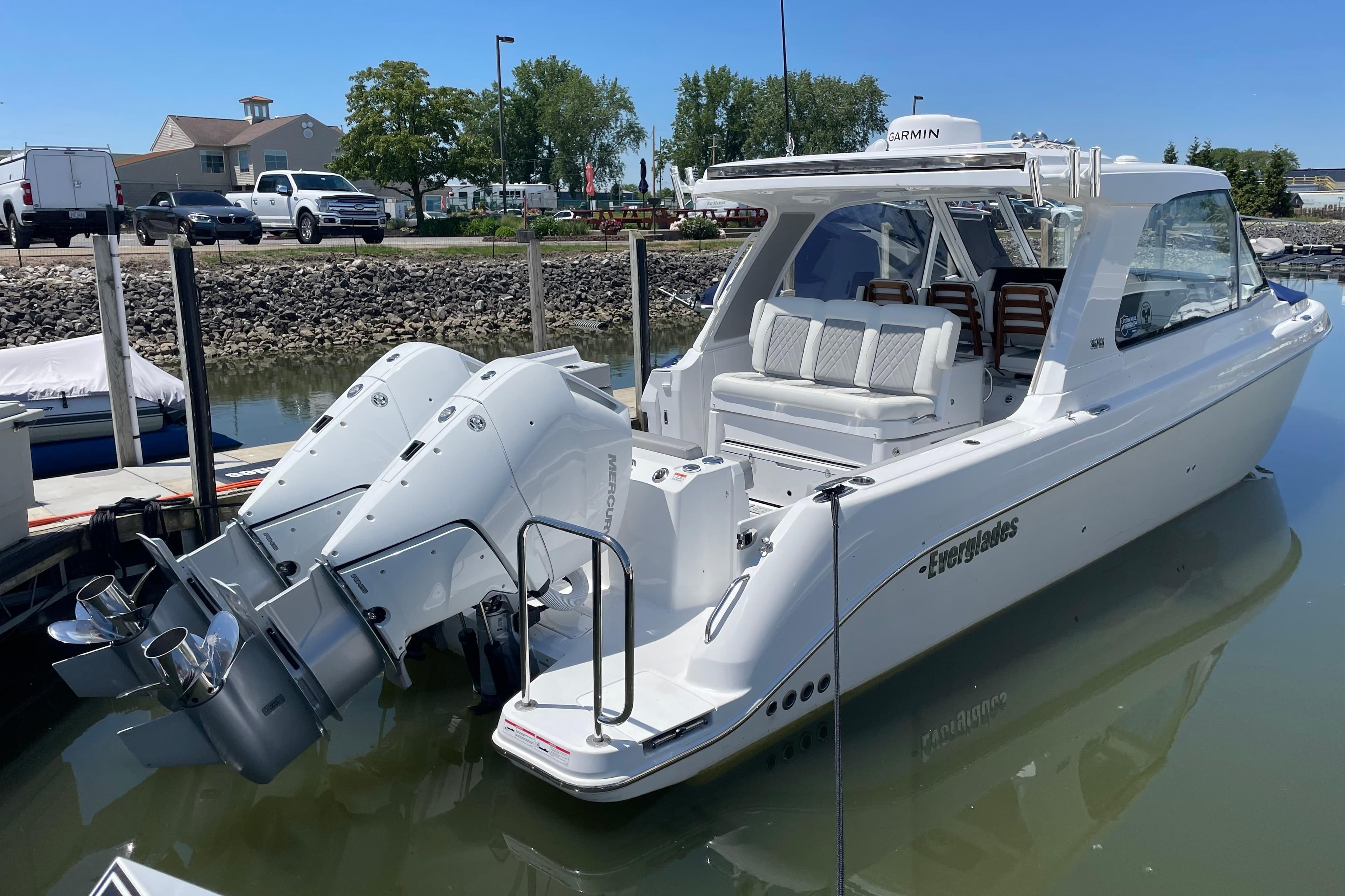 2026 Everglades 367CX boat docked, featuring dual outboard engines and sleek design.