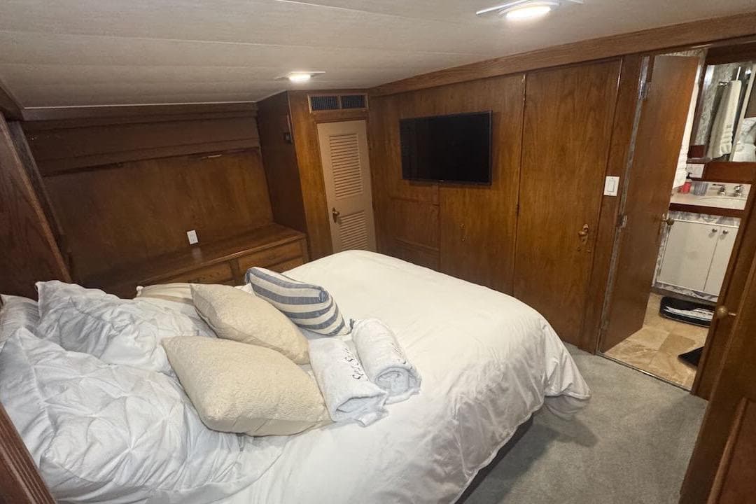 Luxurious bedroom interior of 1974 Burger 67 Motor Yacht with wood paneling and modern amenities.